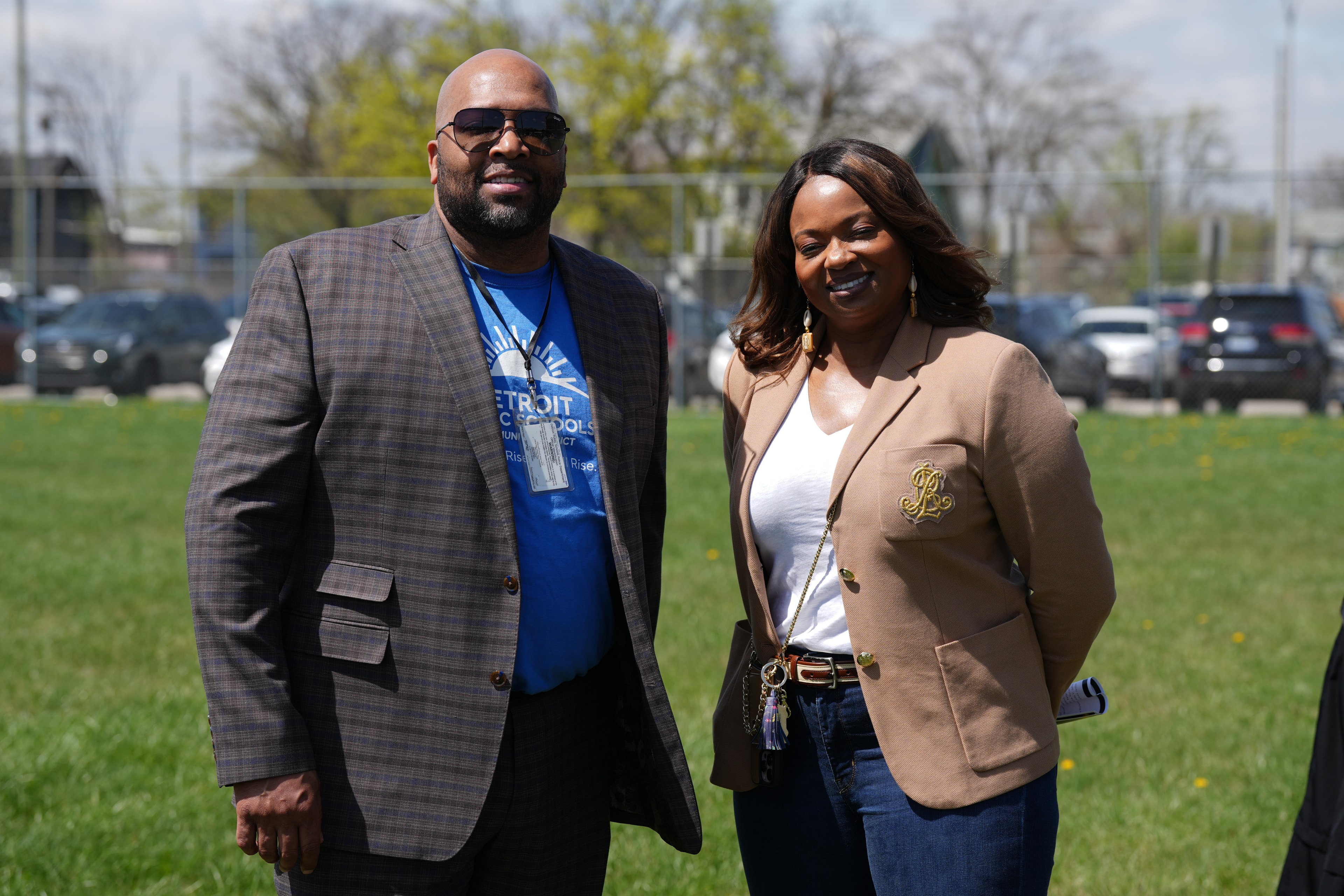 Two people standing on grass field smiling