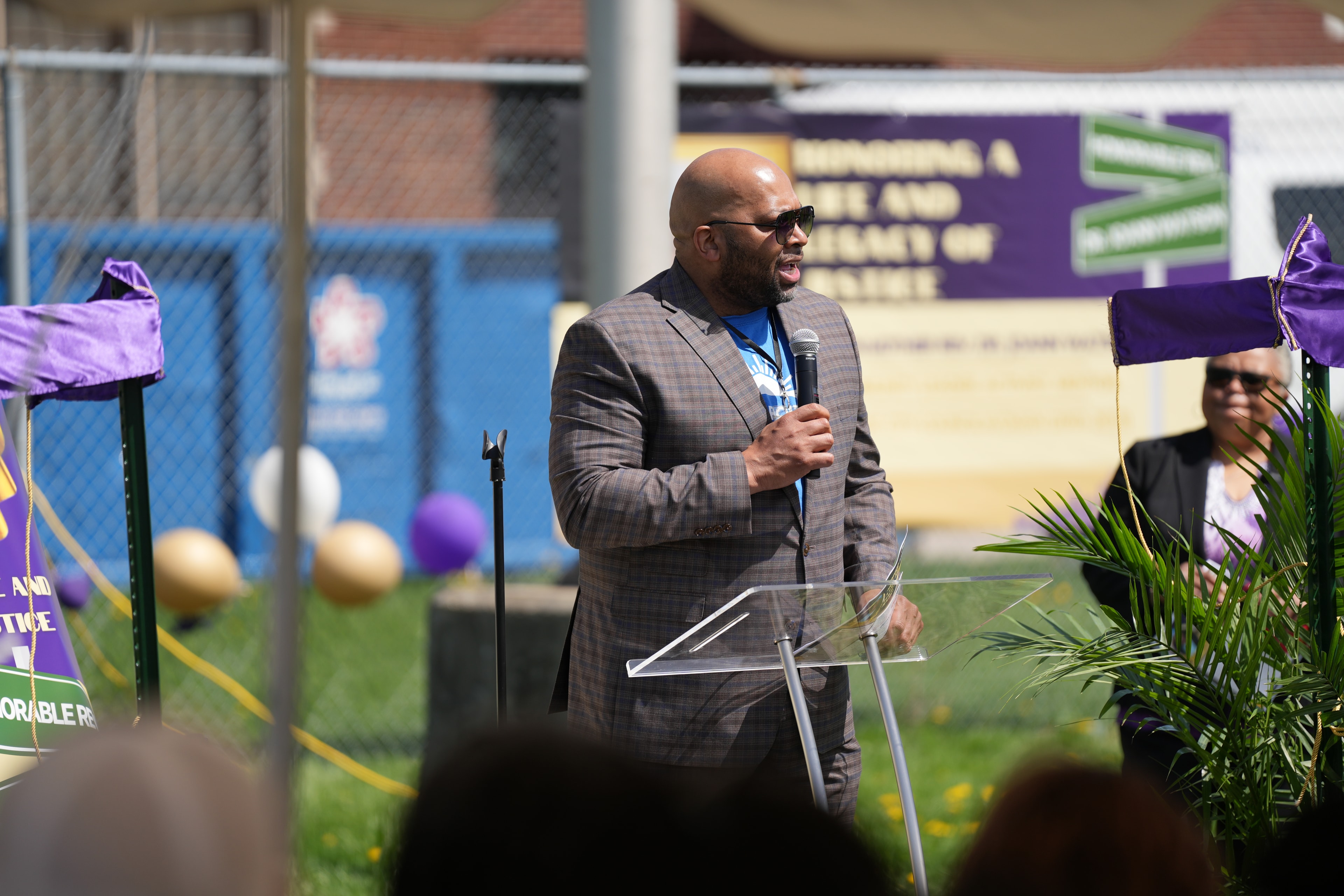 Man speaking at podium outdoor event