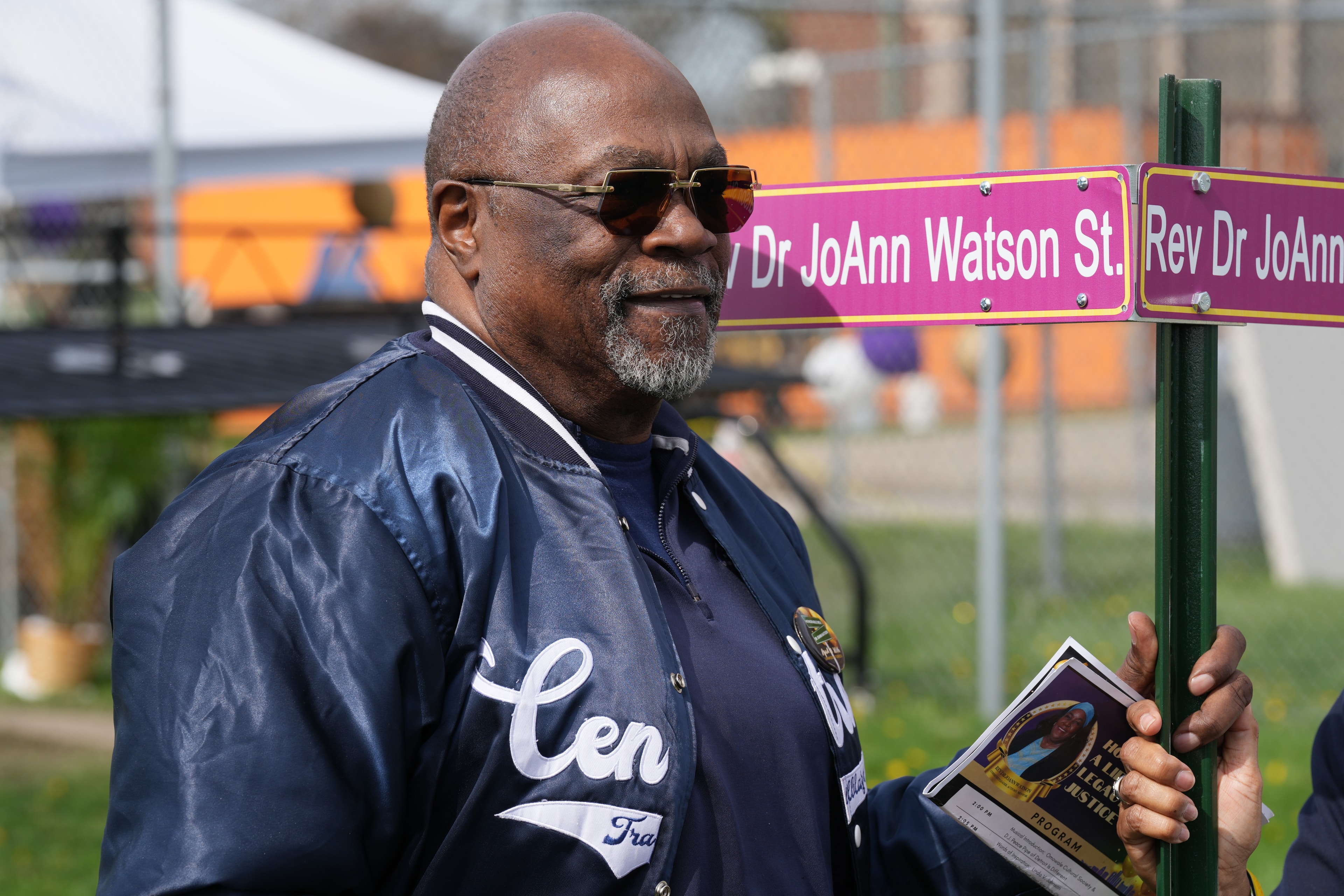 Man holding street sign named after him