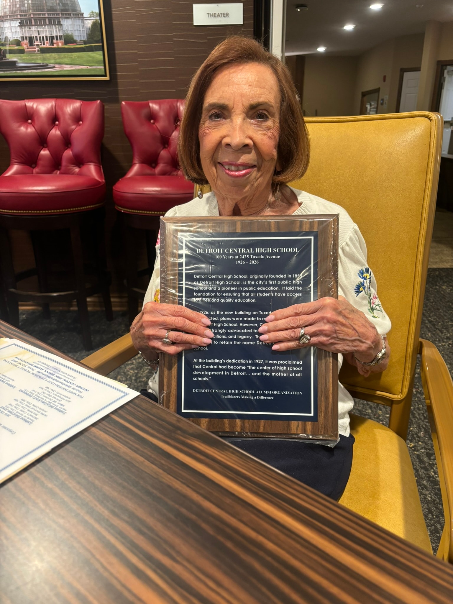 Woman holding Detroit Central High School plaque