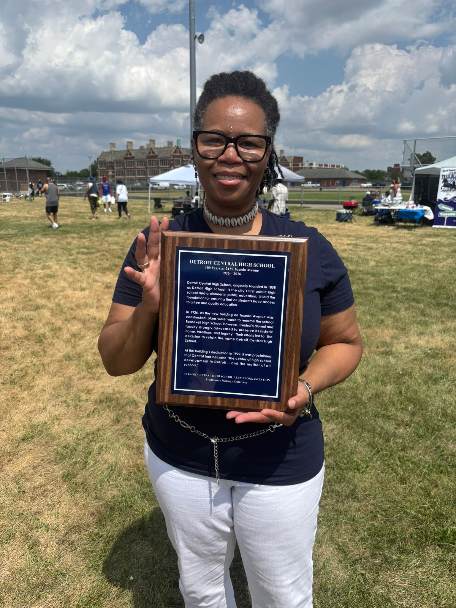 Woman holding Detroit Central High School plaque