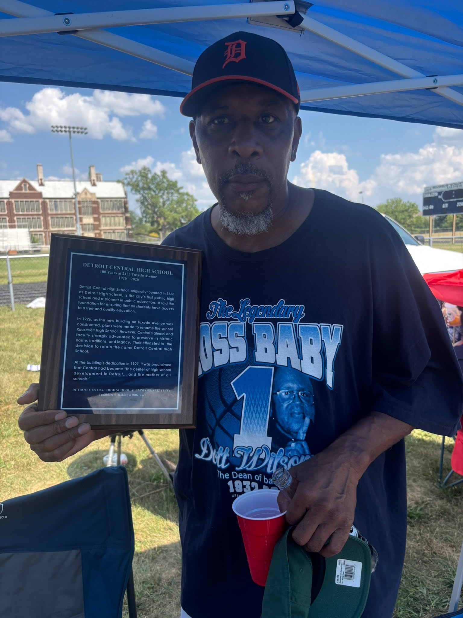 Man holding Detroit Central High School plaque