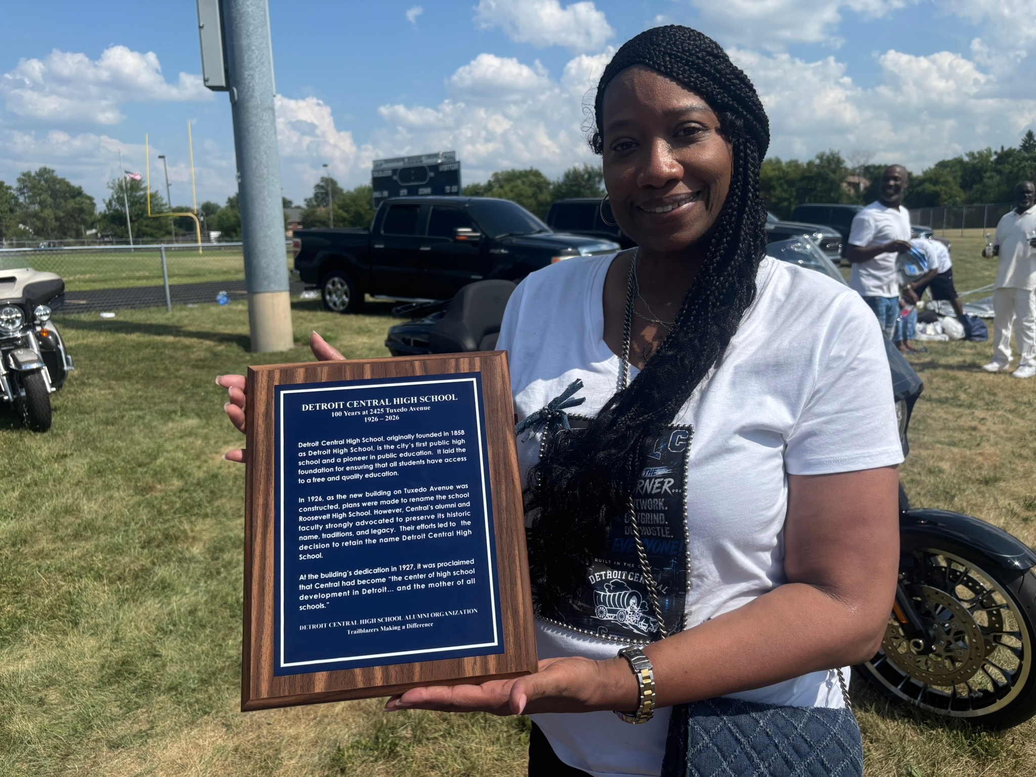Woman holding Detroit Central High School plaque