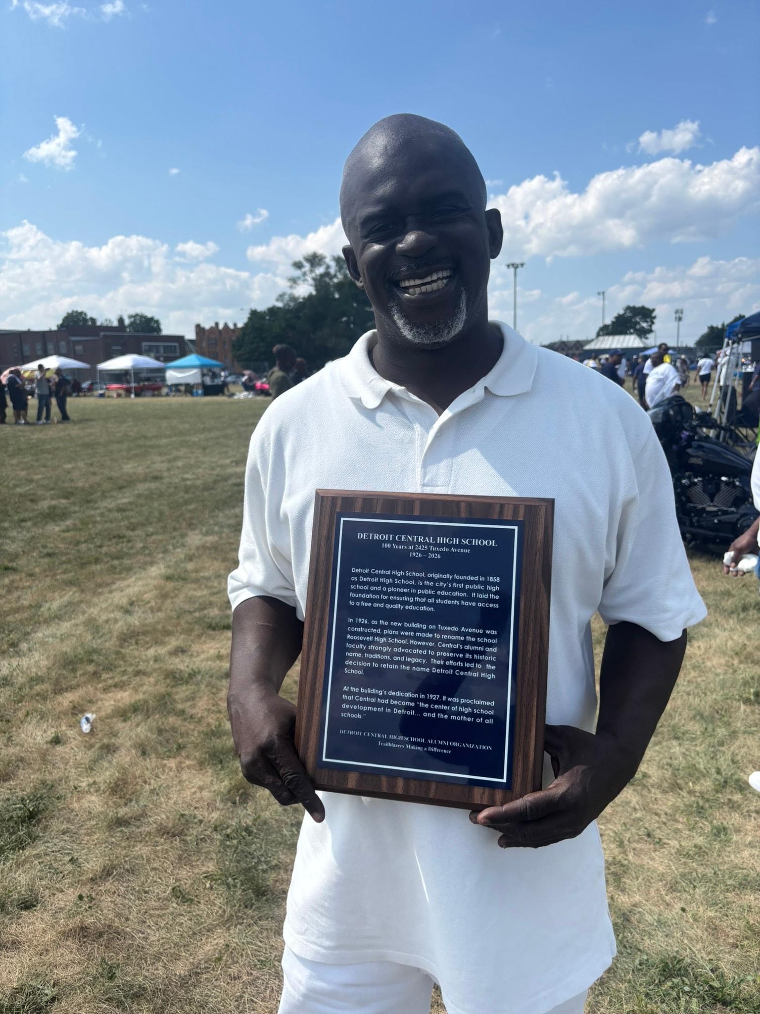 Man holding Detroit Central High School plaque