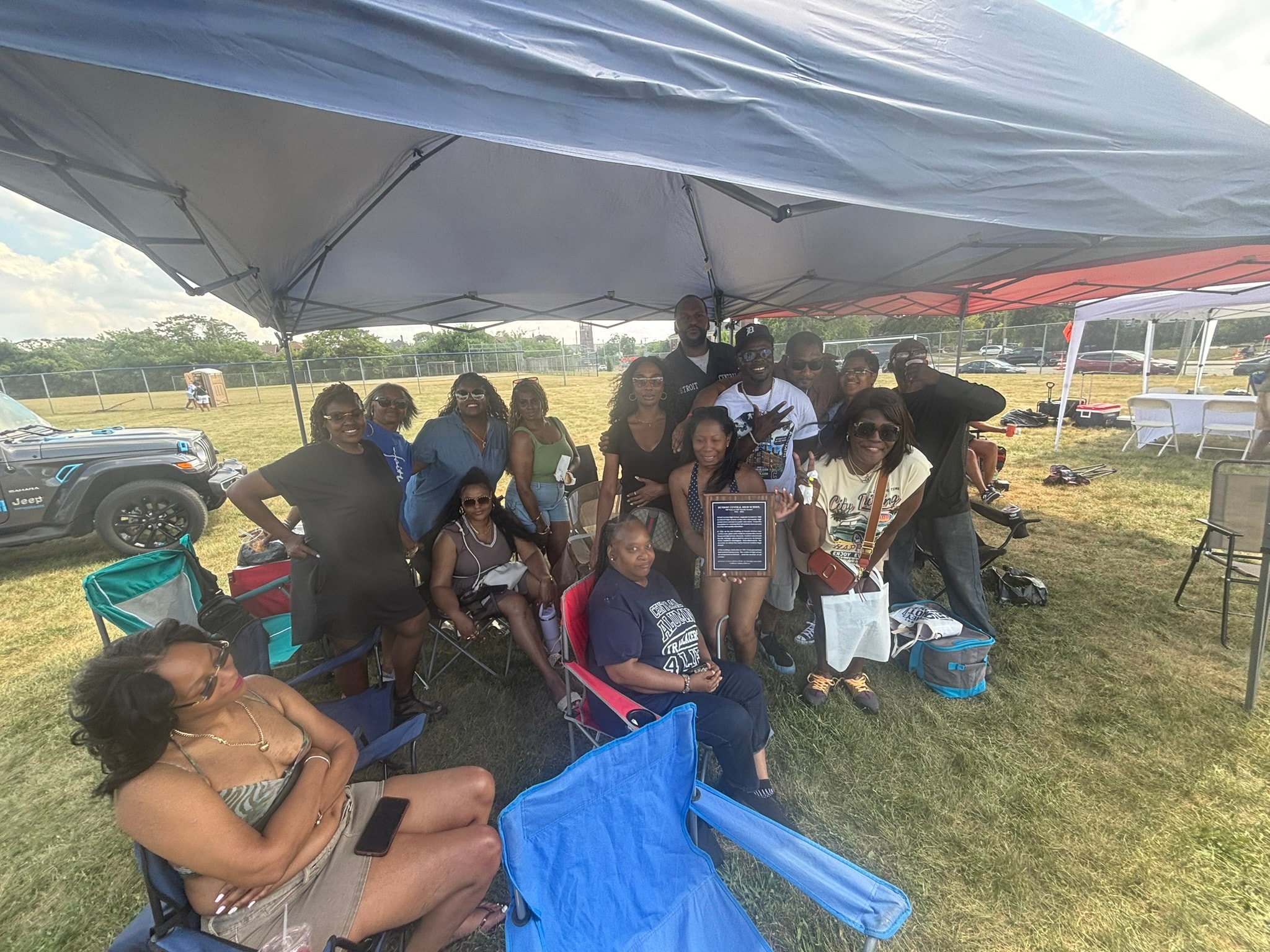 Group gathering under tent at outdoor event