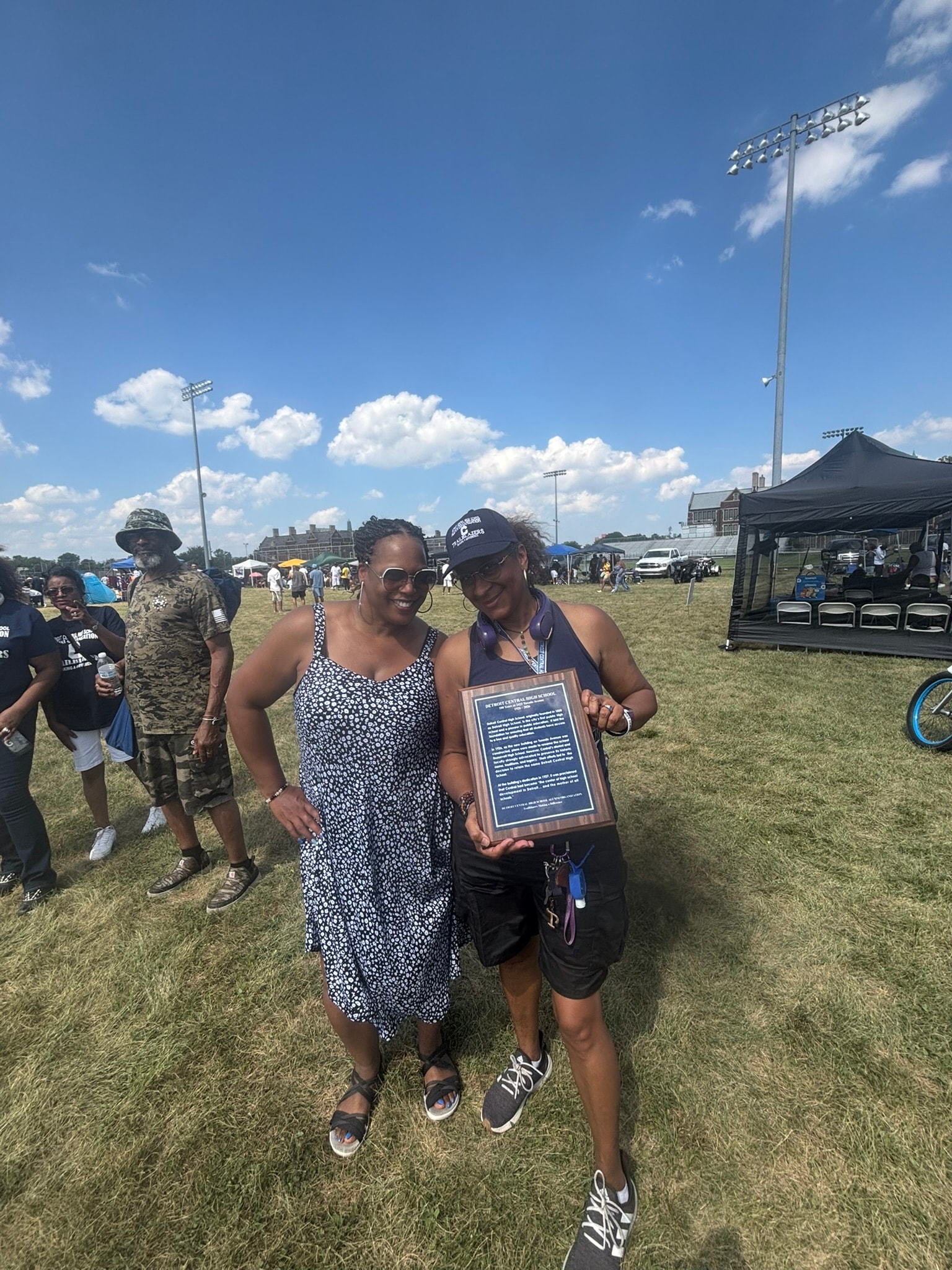 Two women holding award at outdoor event
