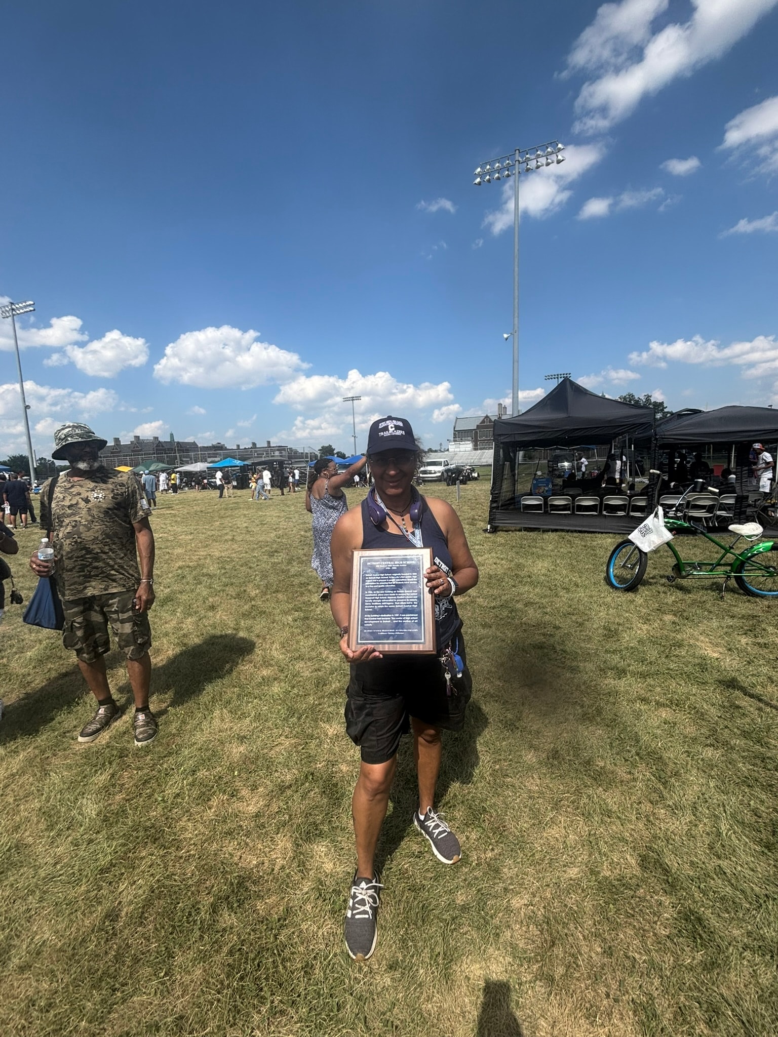 Woman holding award at outdoor event