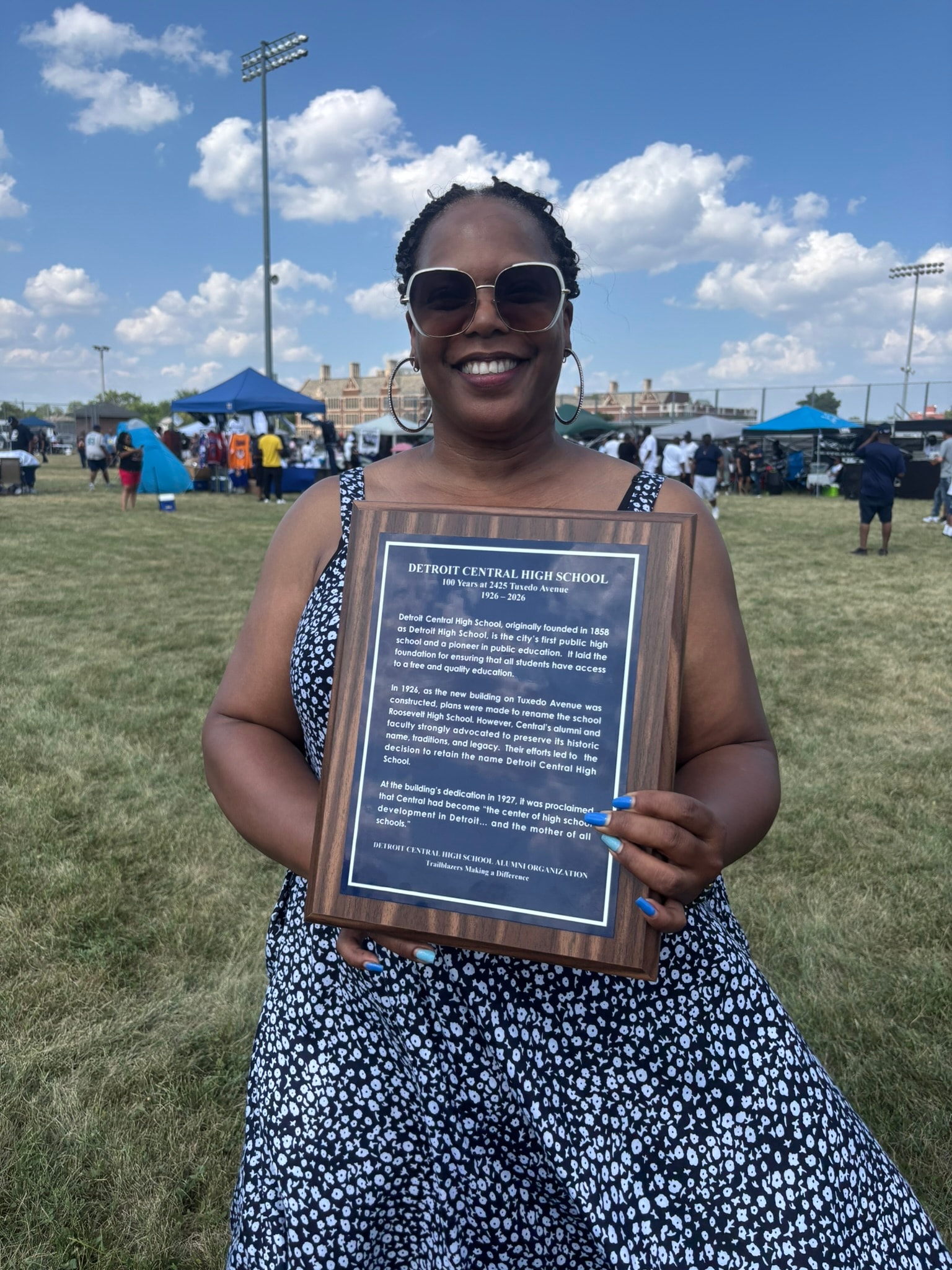 Woman holding Detroit Central High School plaque