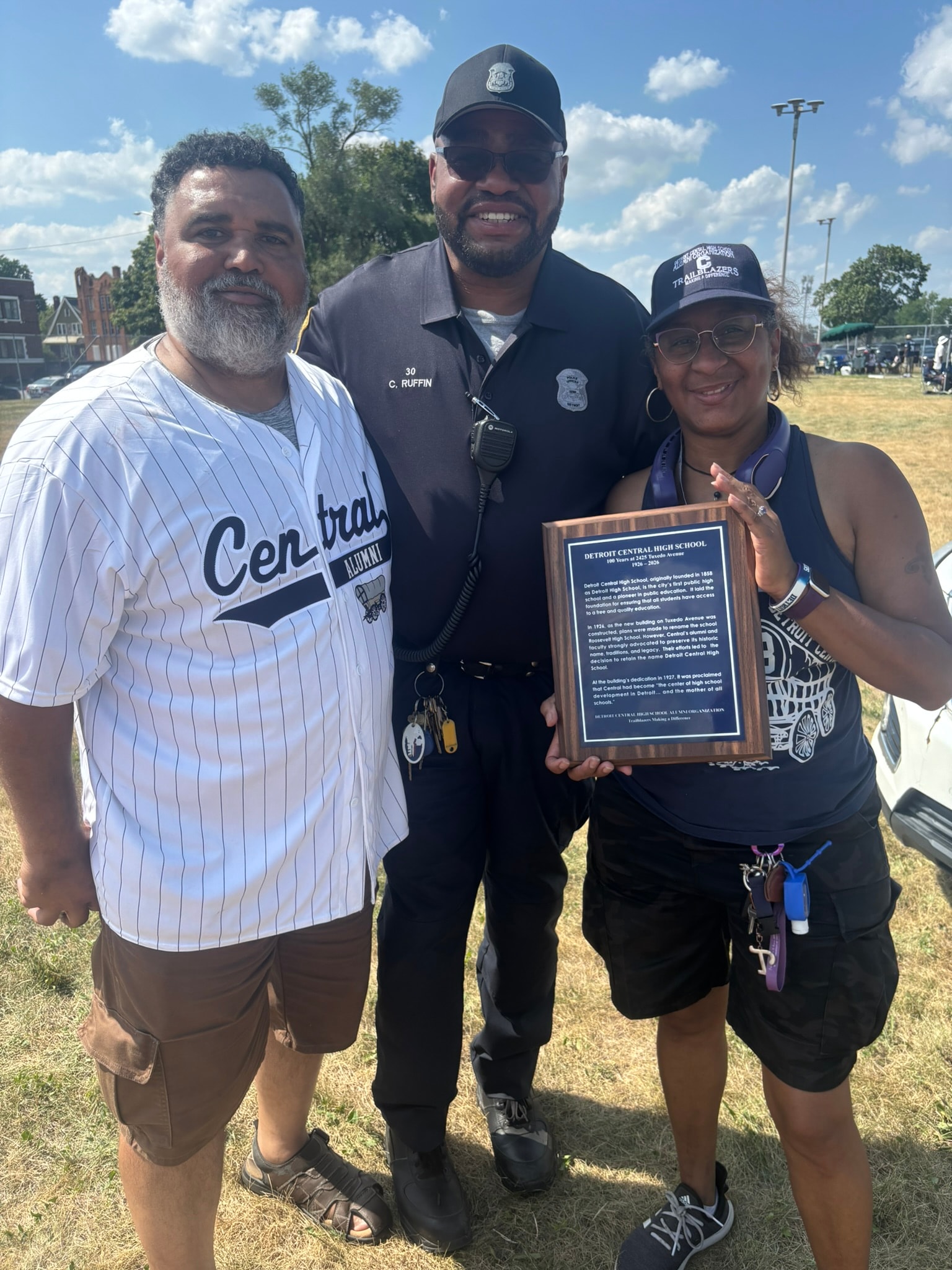 Police officer with community members holding plaque