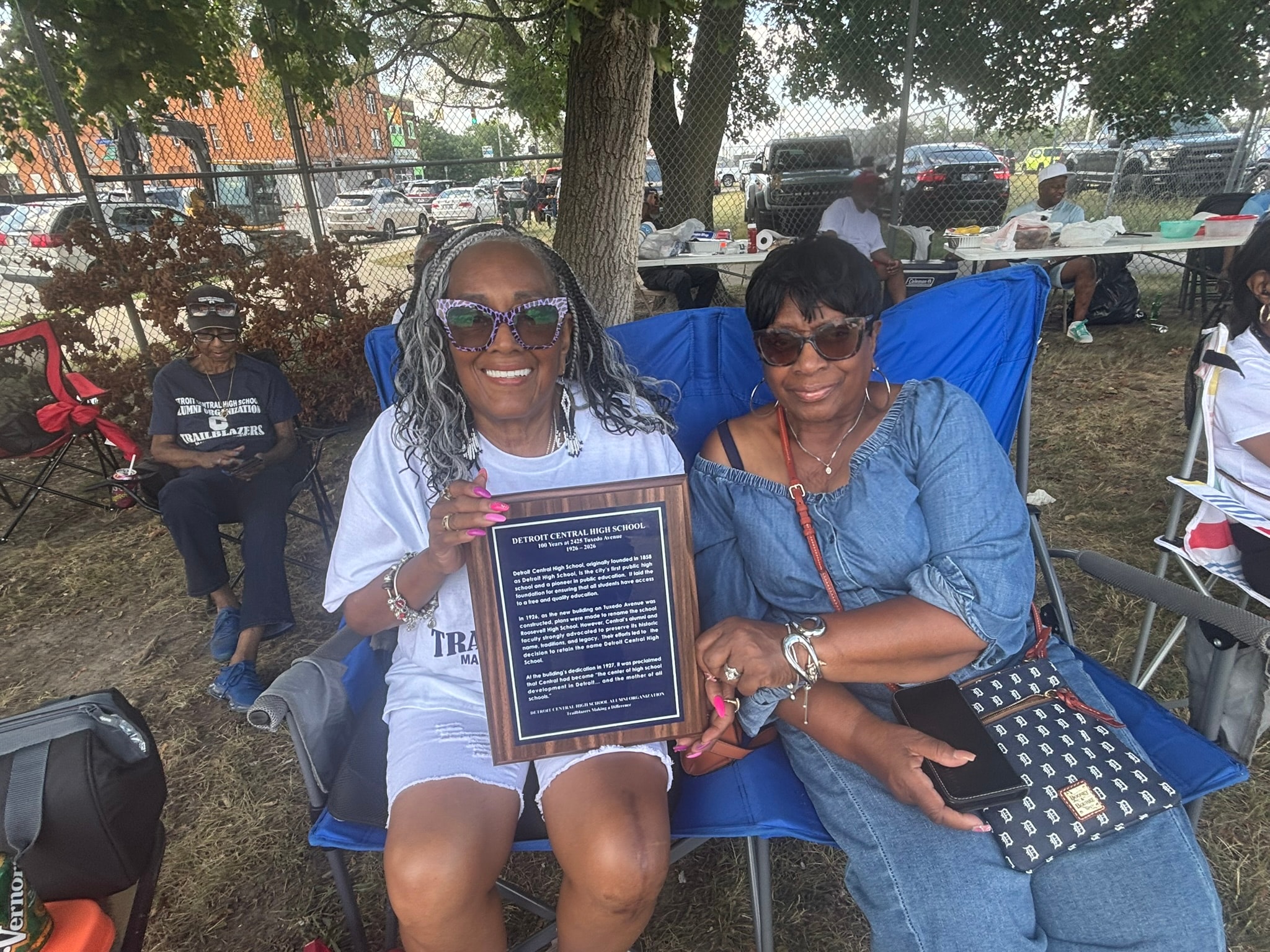 Women holding Detroit Central High School plaque