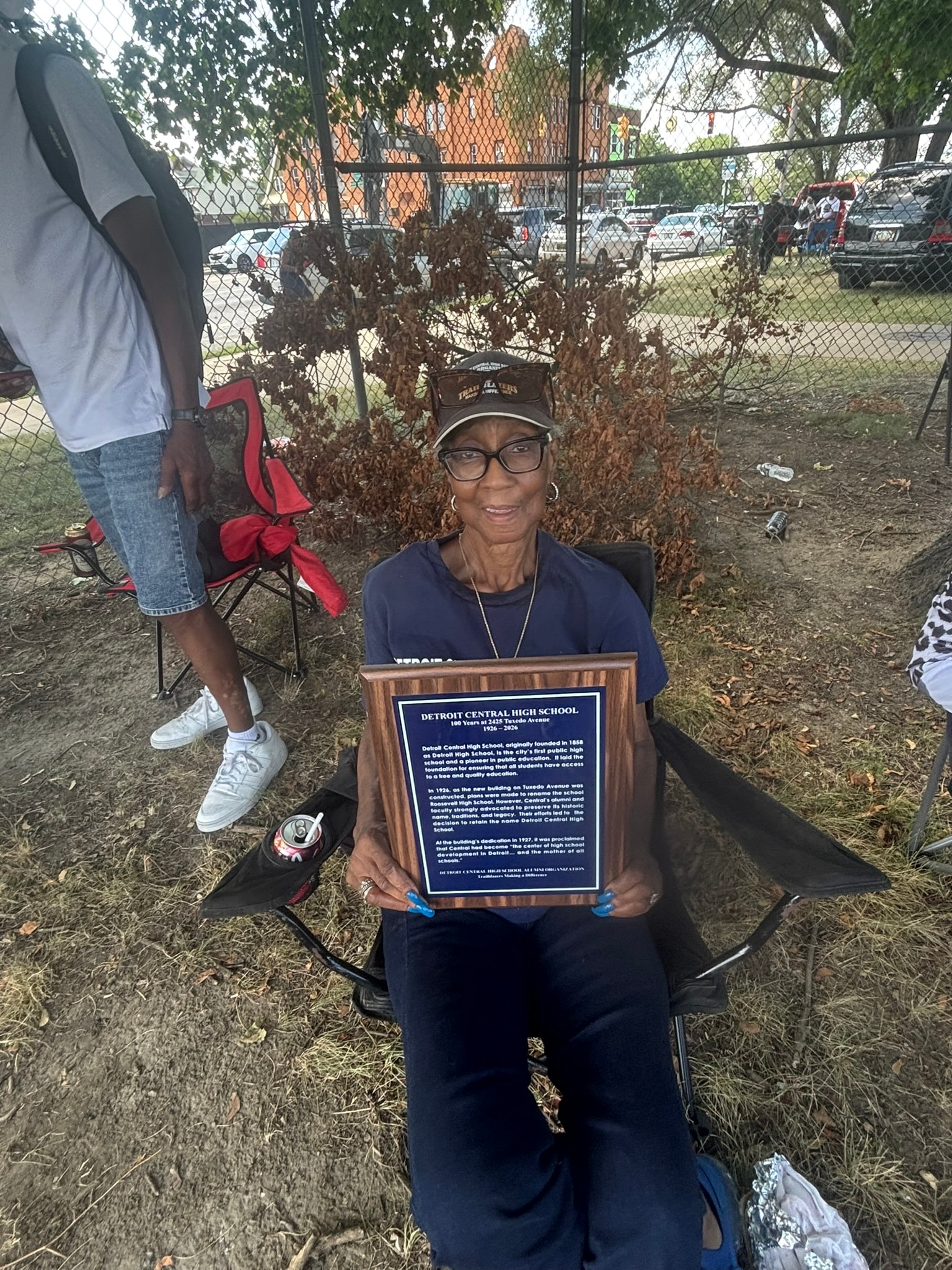 Woman holding Detroit Central High School plaque