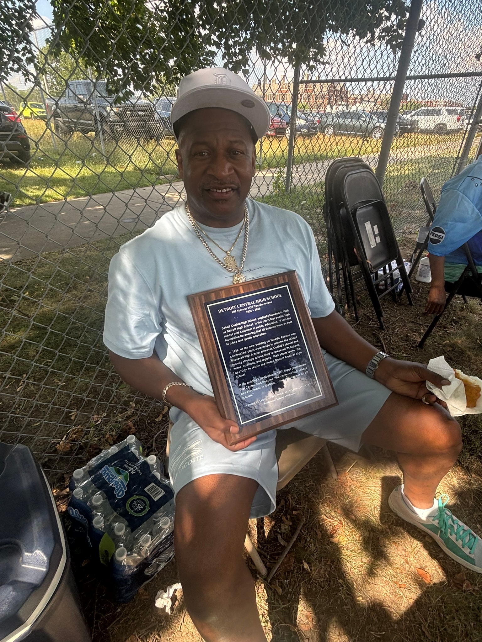 Man holding commemorative plaque baseball field