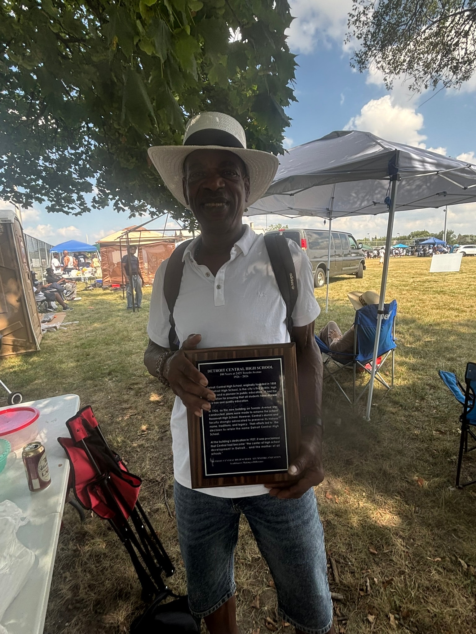 Man holding commemorative plaque outdoor event