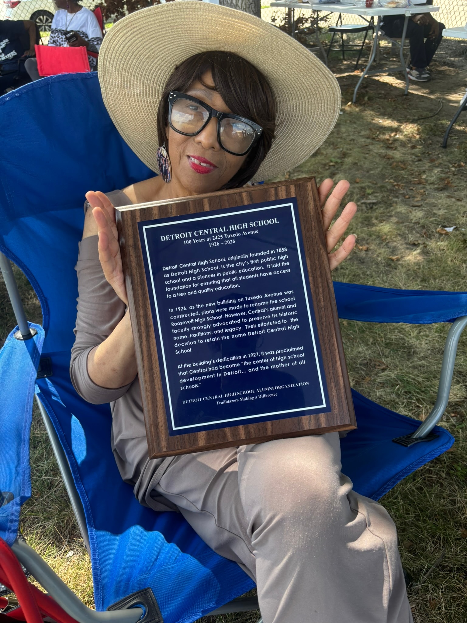 Woman holding Detroit Central High School plaque