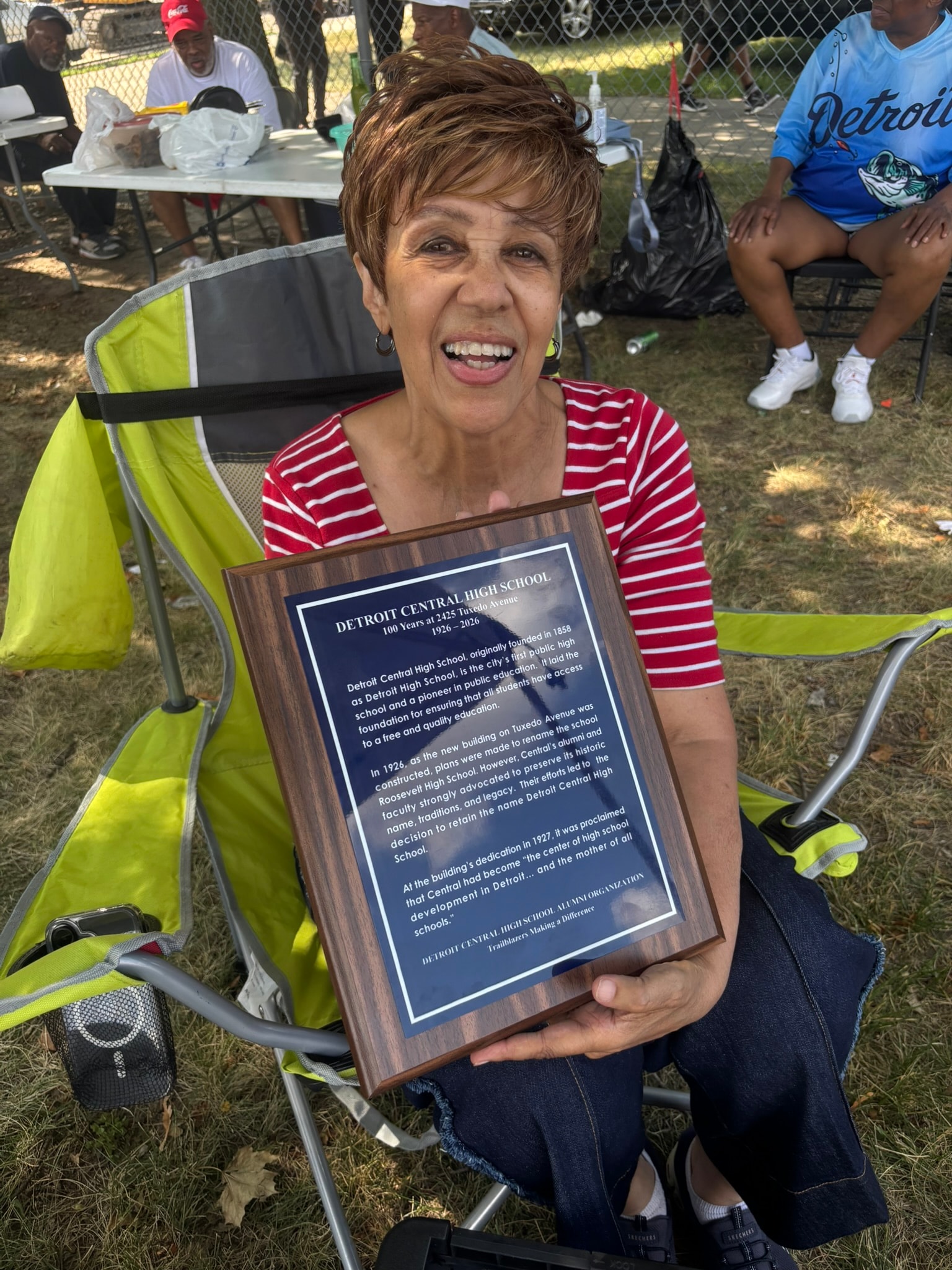 Woman holding Detroit Central High School plaque