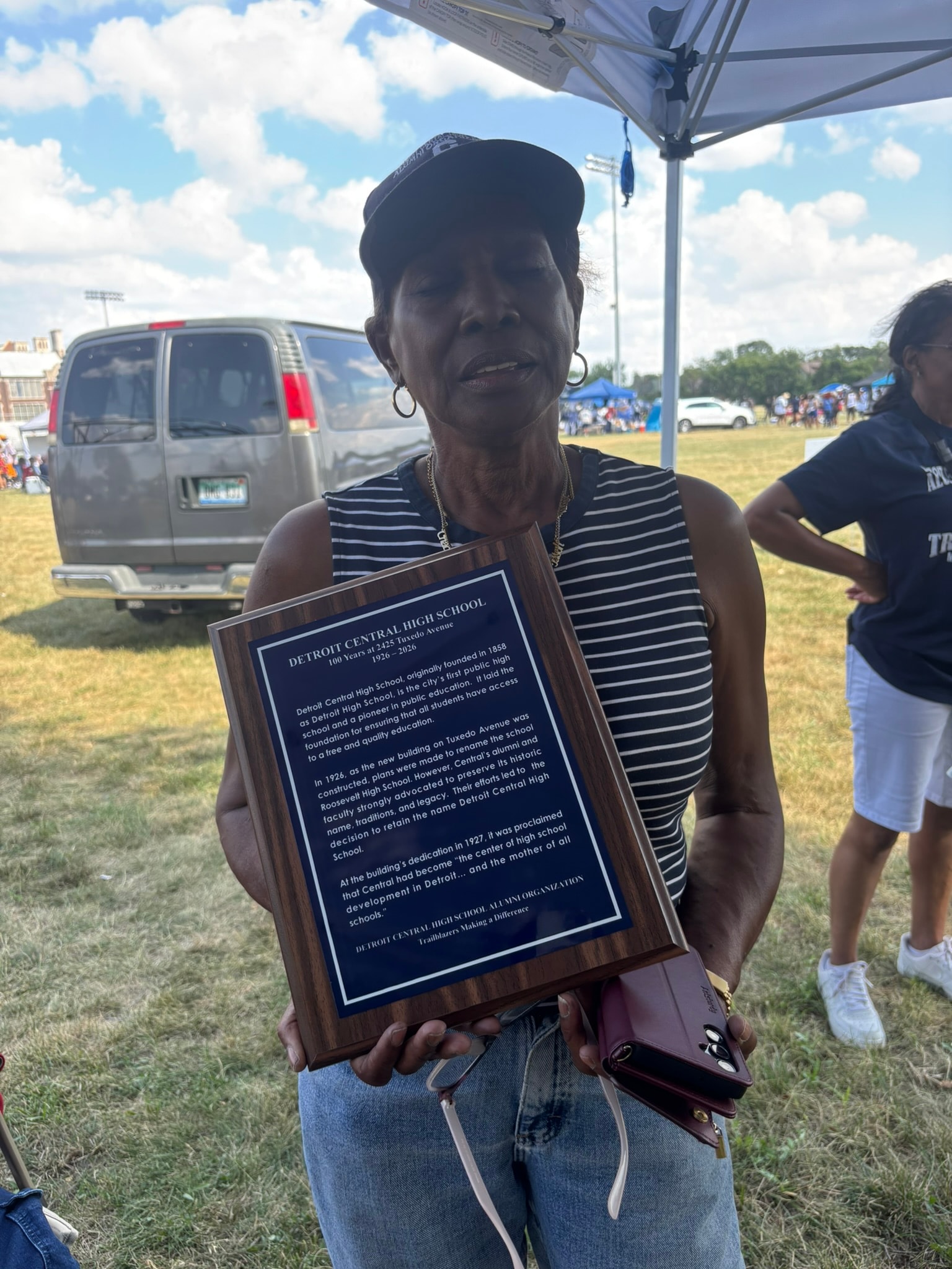 Woman holding Detroit Central High School plaque