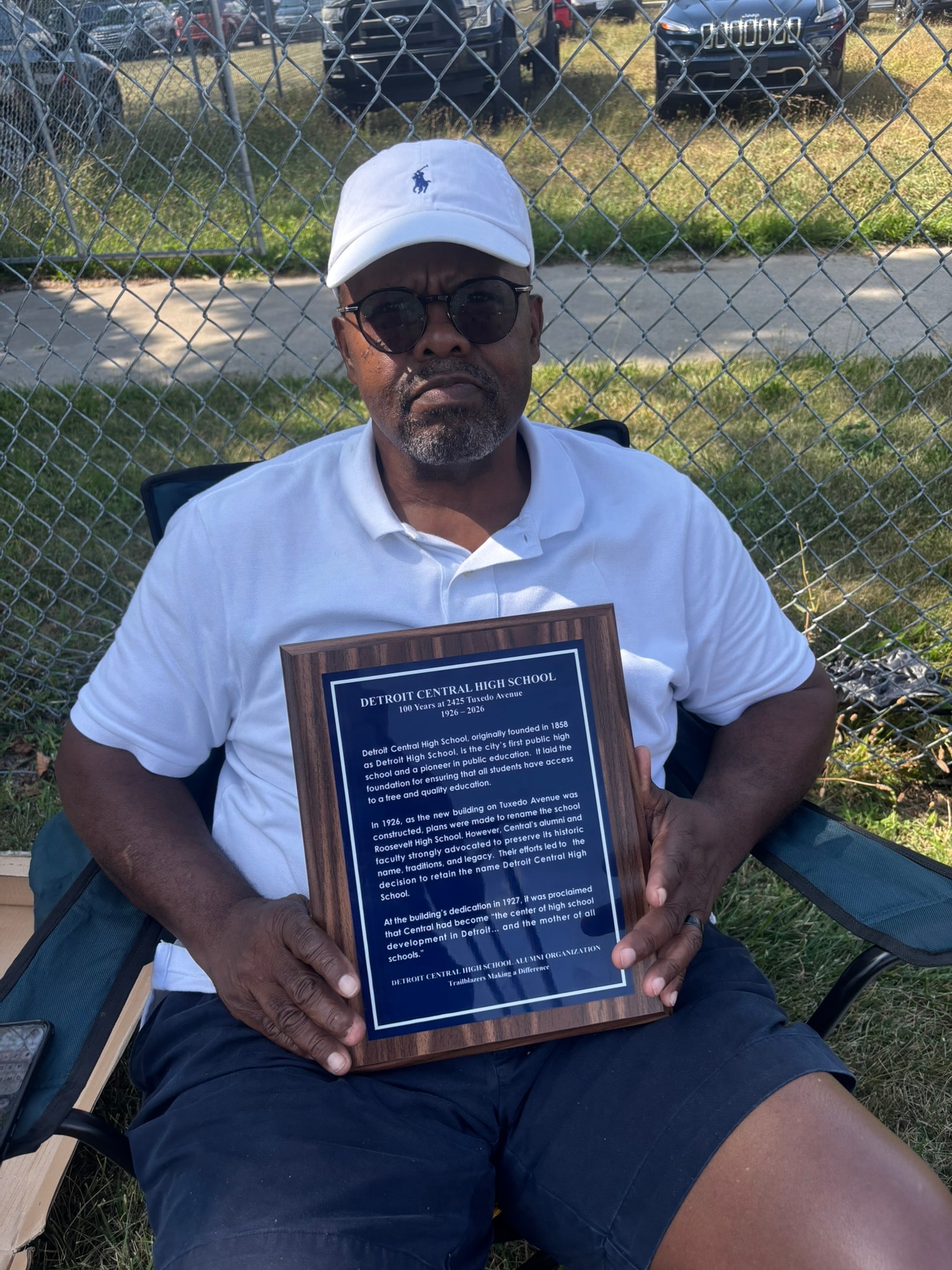 Man holding Detroit Central High School plaque