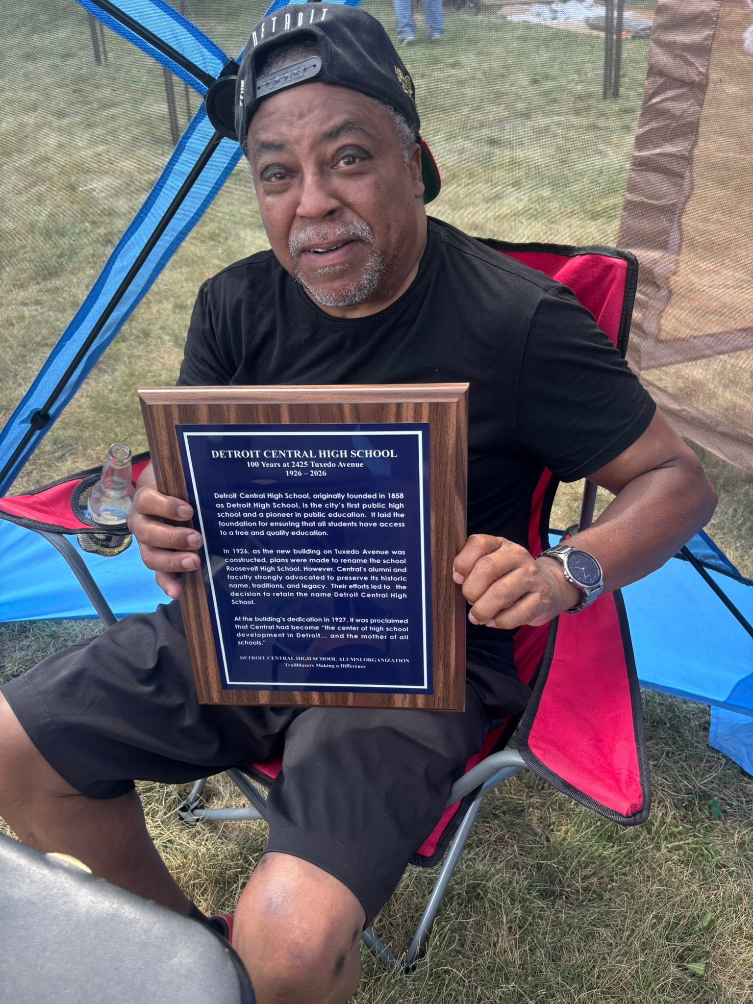 Man holding Detroit Central High School plaque