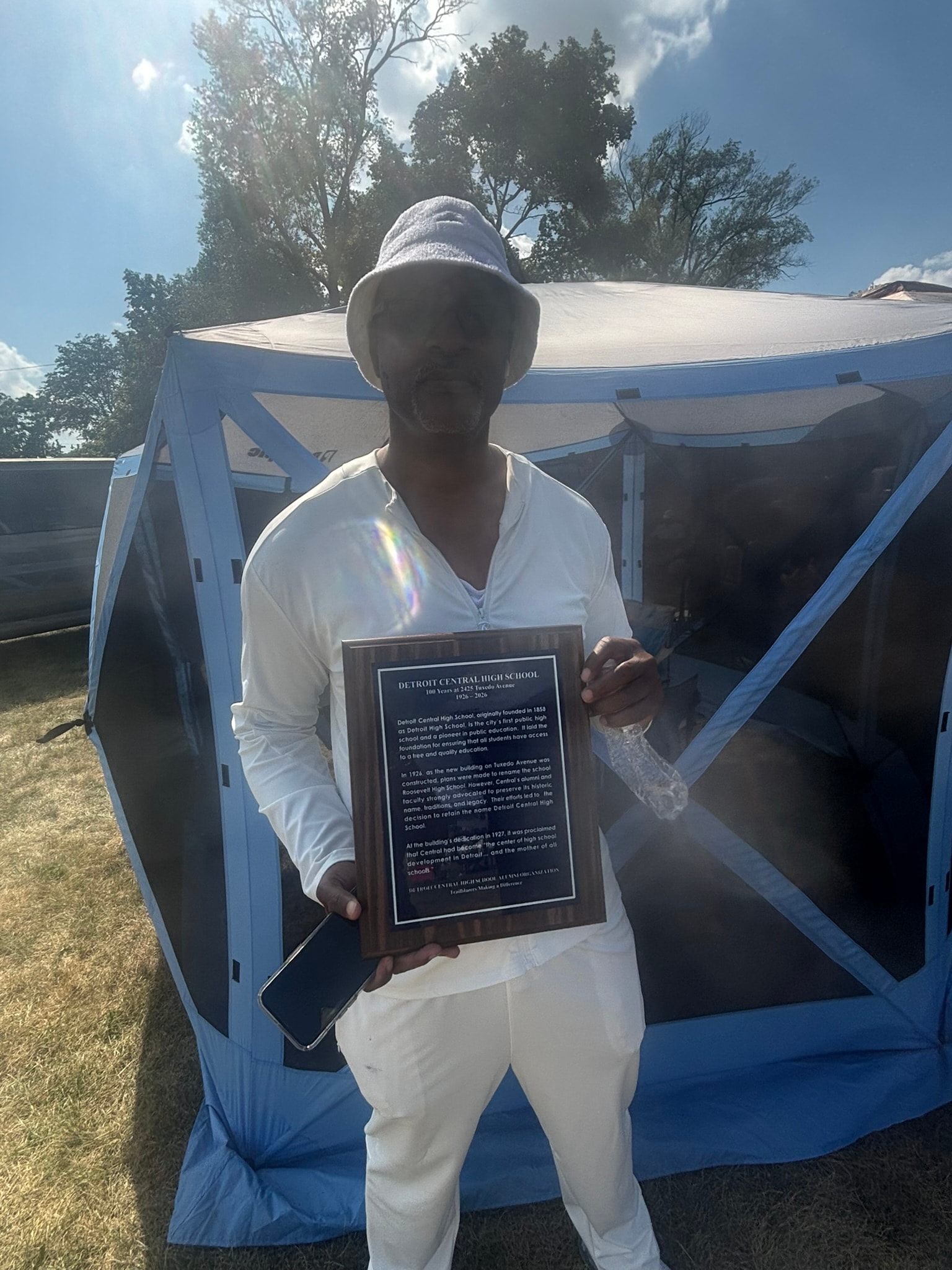 Person holding historical plaque outdoors