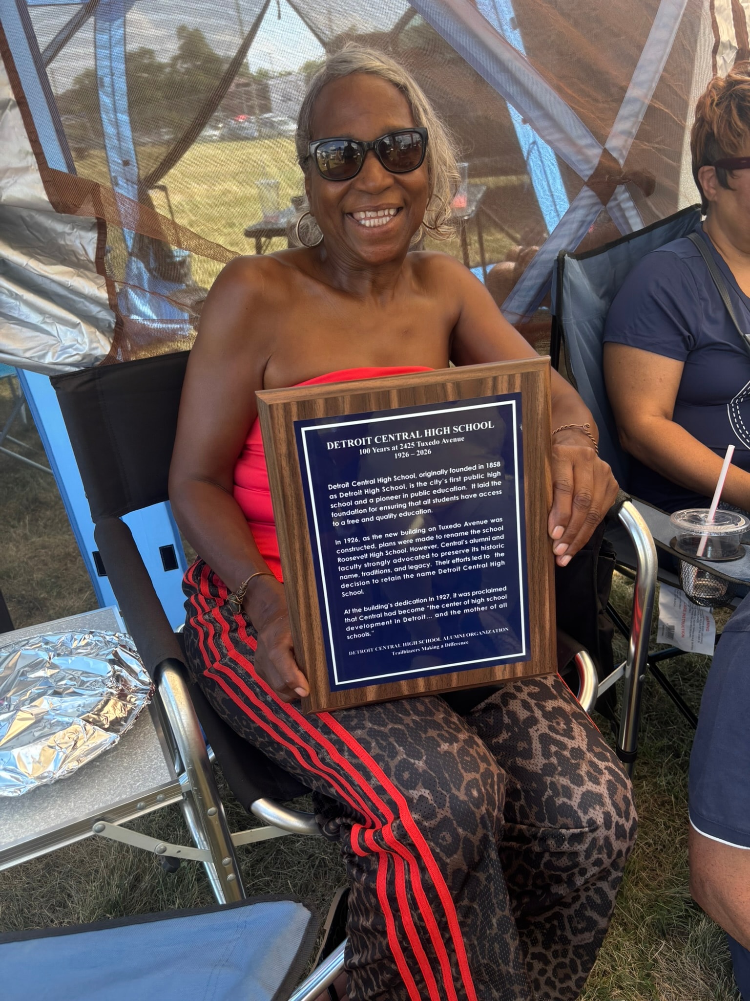 Woman holding Detroit Central High School plaque
