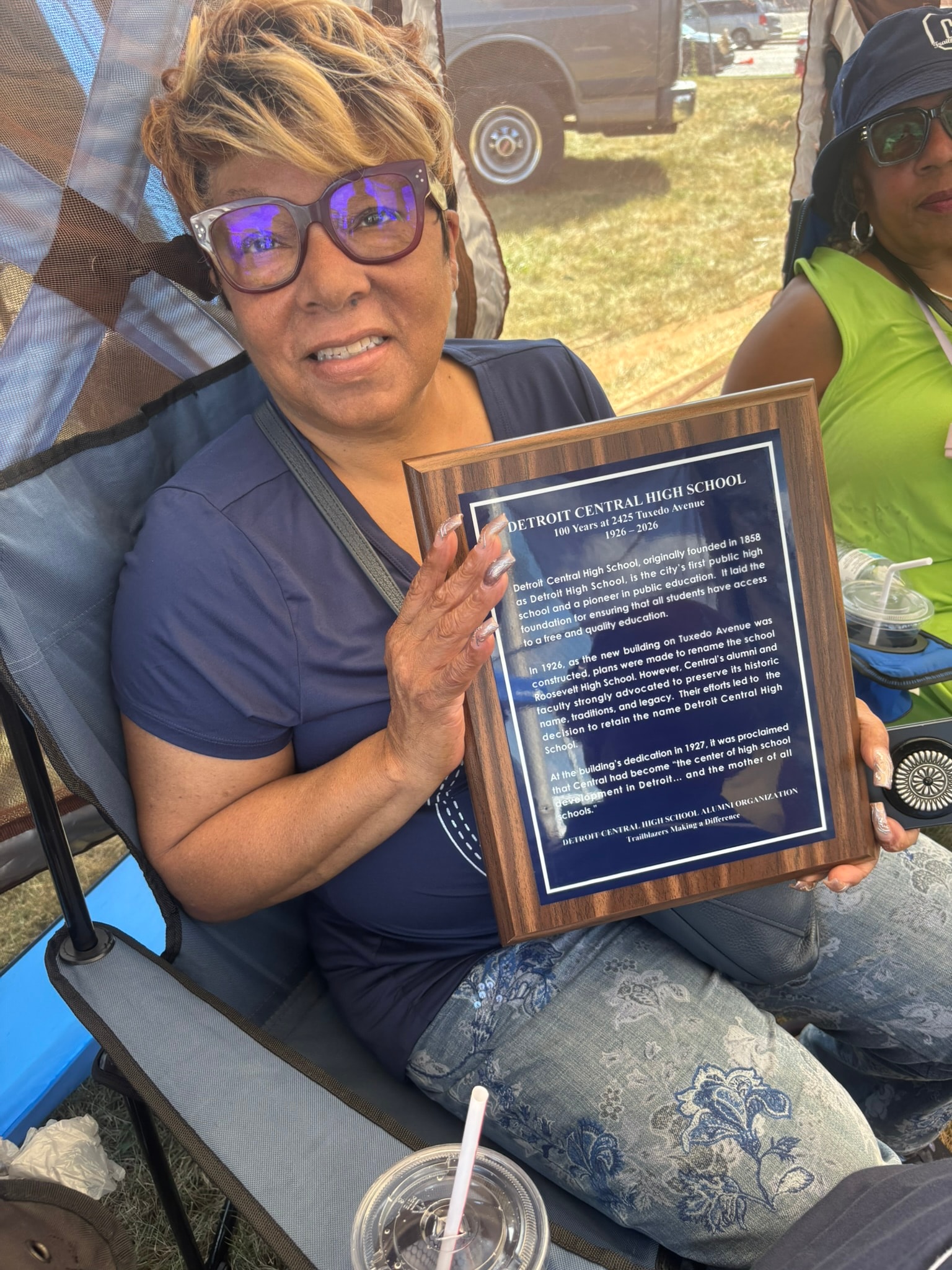 Woman holding Detroit Central High School plaque