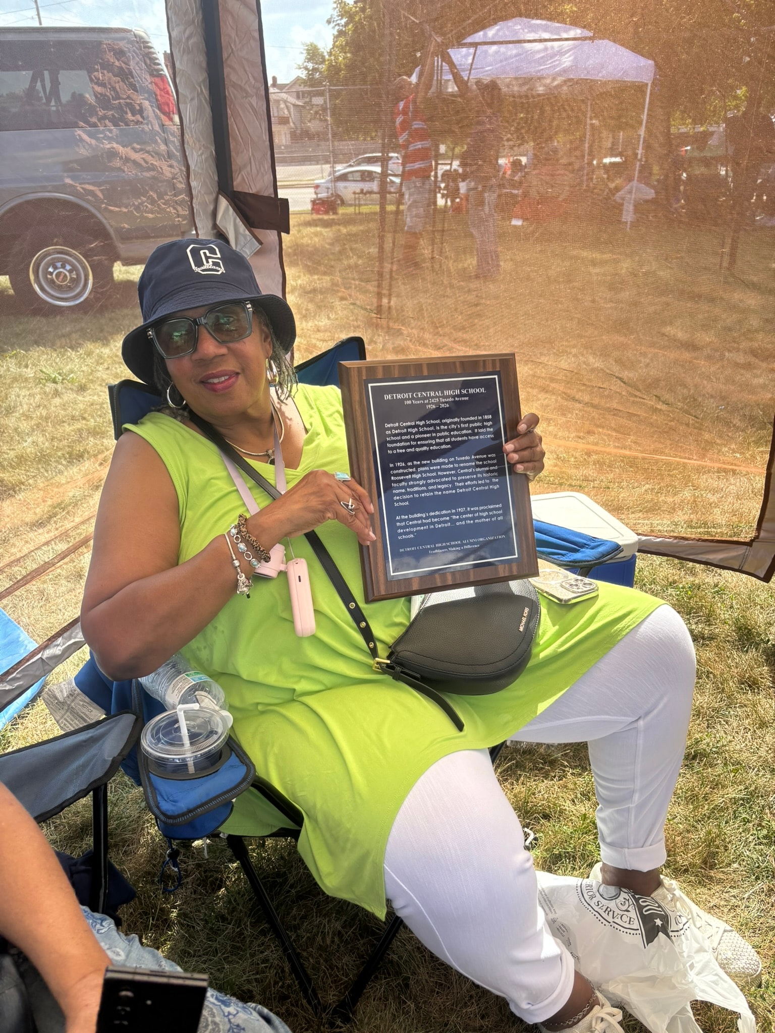 Woman holding Detroit Central High School plaque
