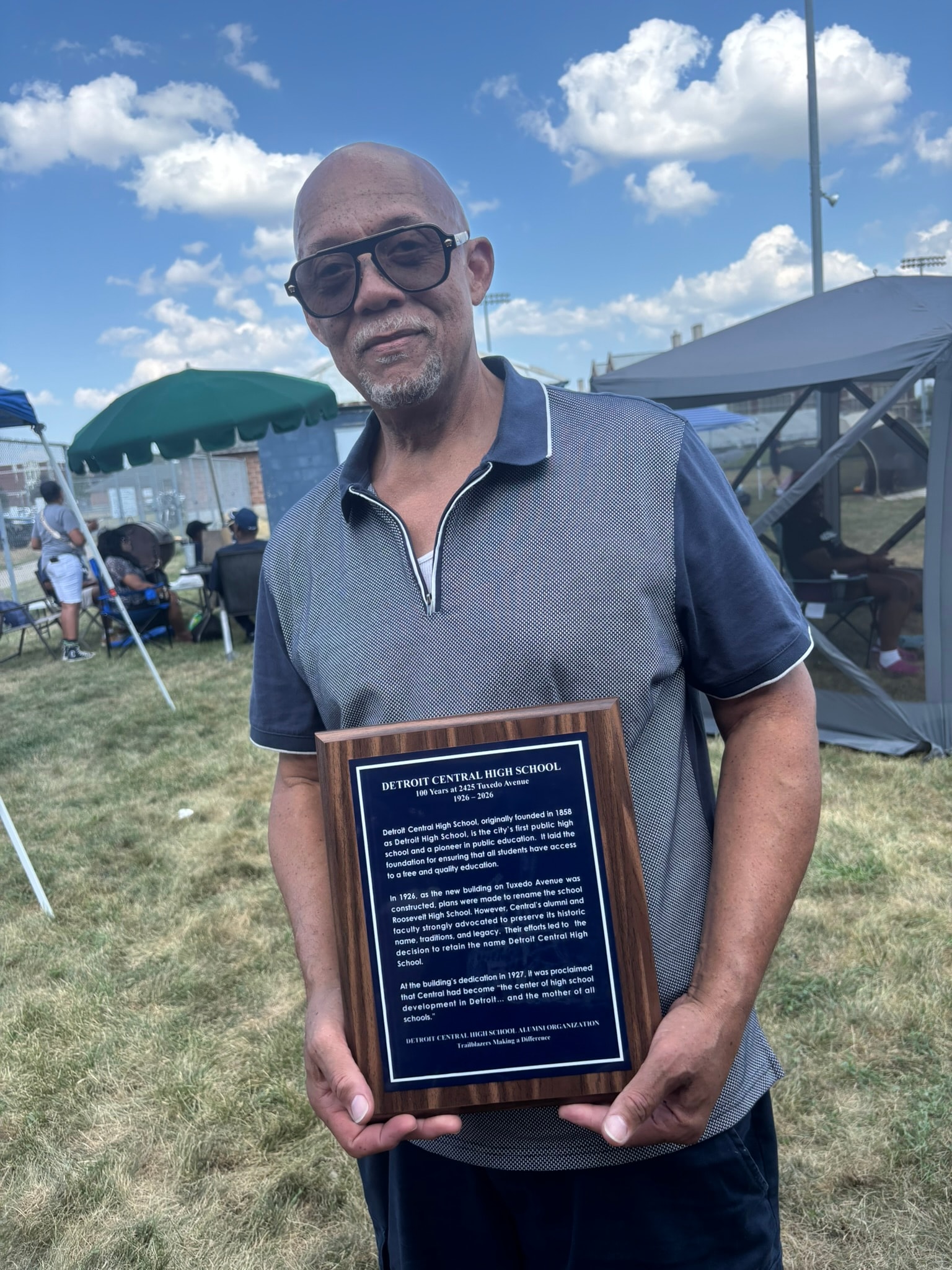 Man holding Detroit Central High School plaque