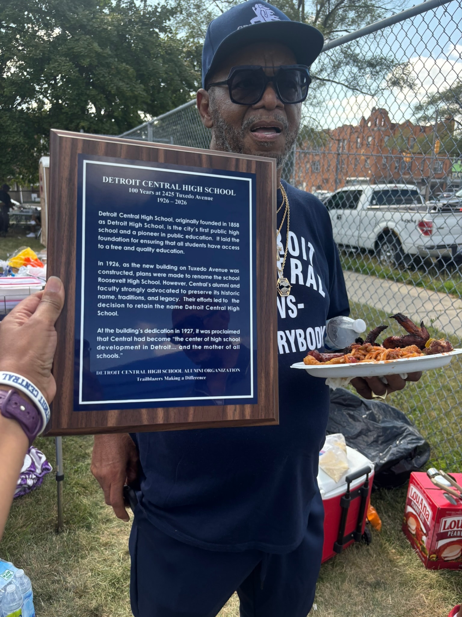 Man holding Detroit Central High School plaque
