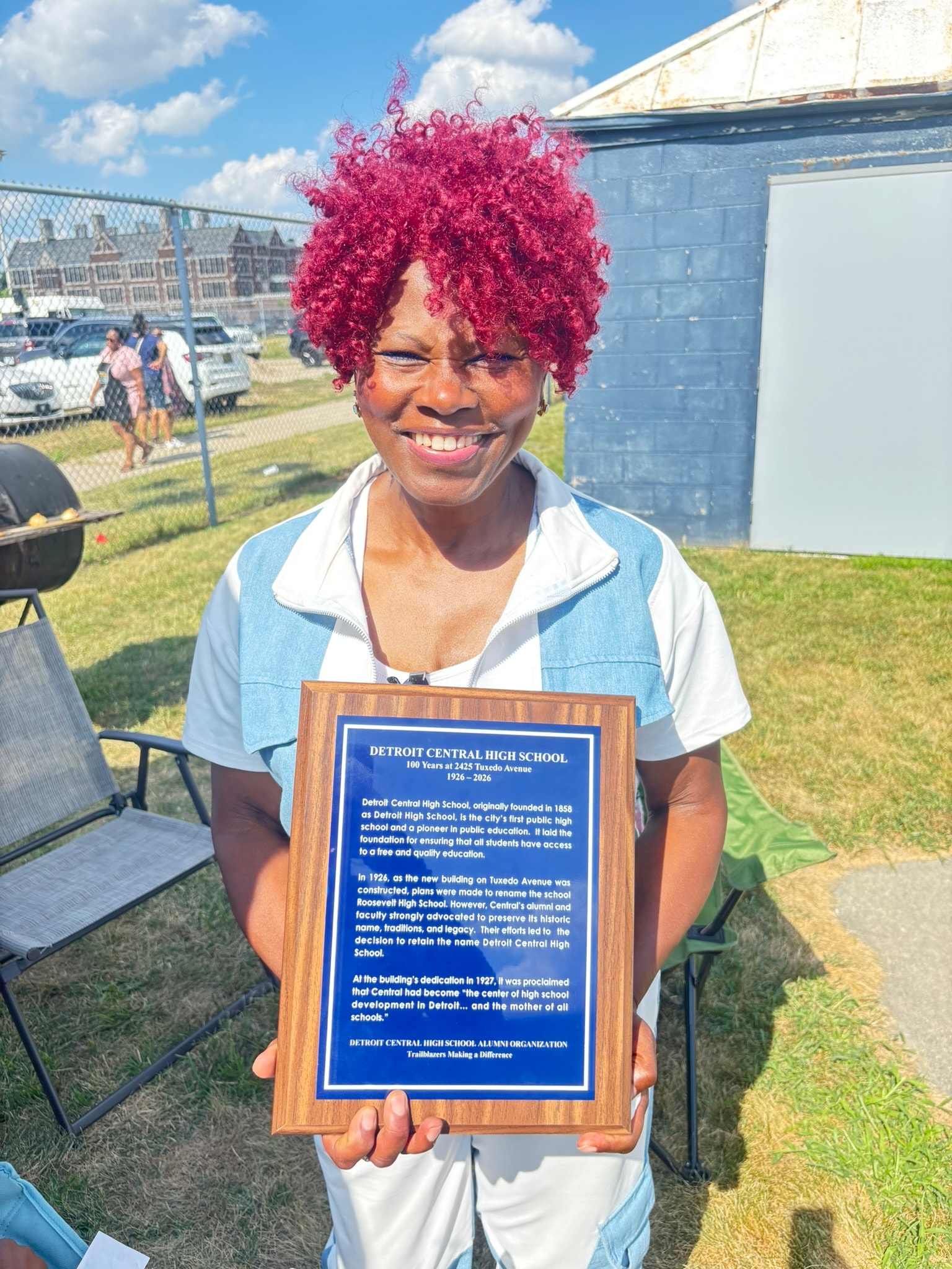 Woman holding Detroit Central High School plaque