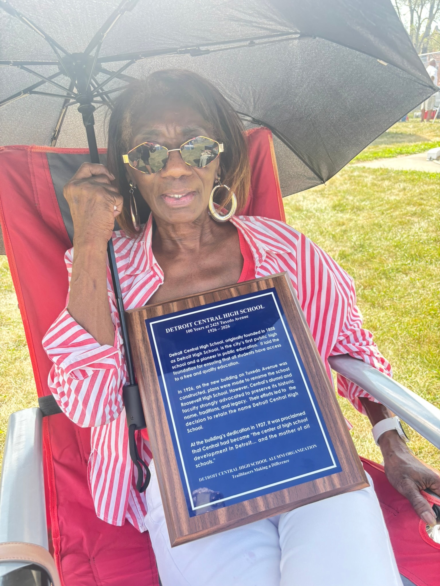 Woman holding Detroit Central High School plaque