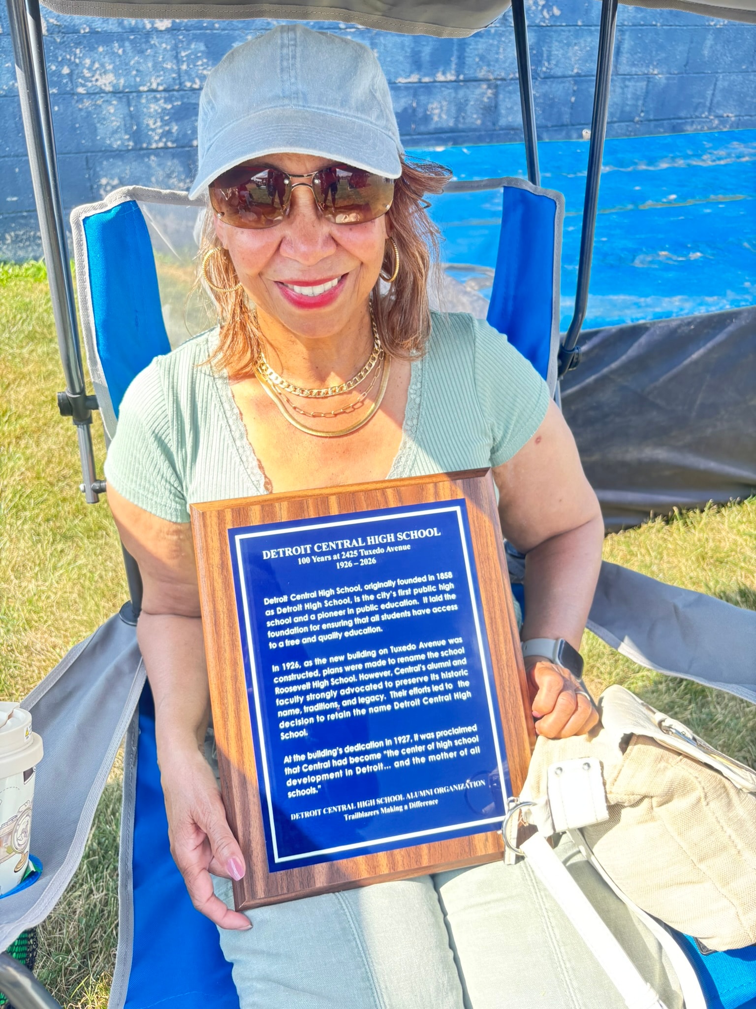 Woman holding Detroit Central High School plaque