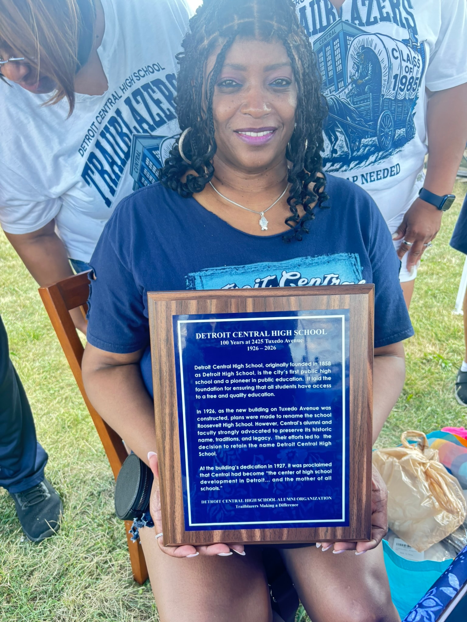 Woman holding Detroit Central High School plaque