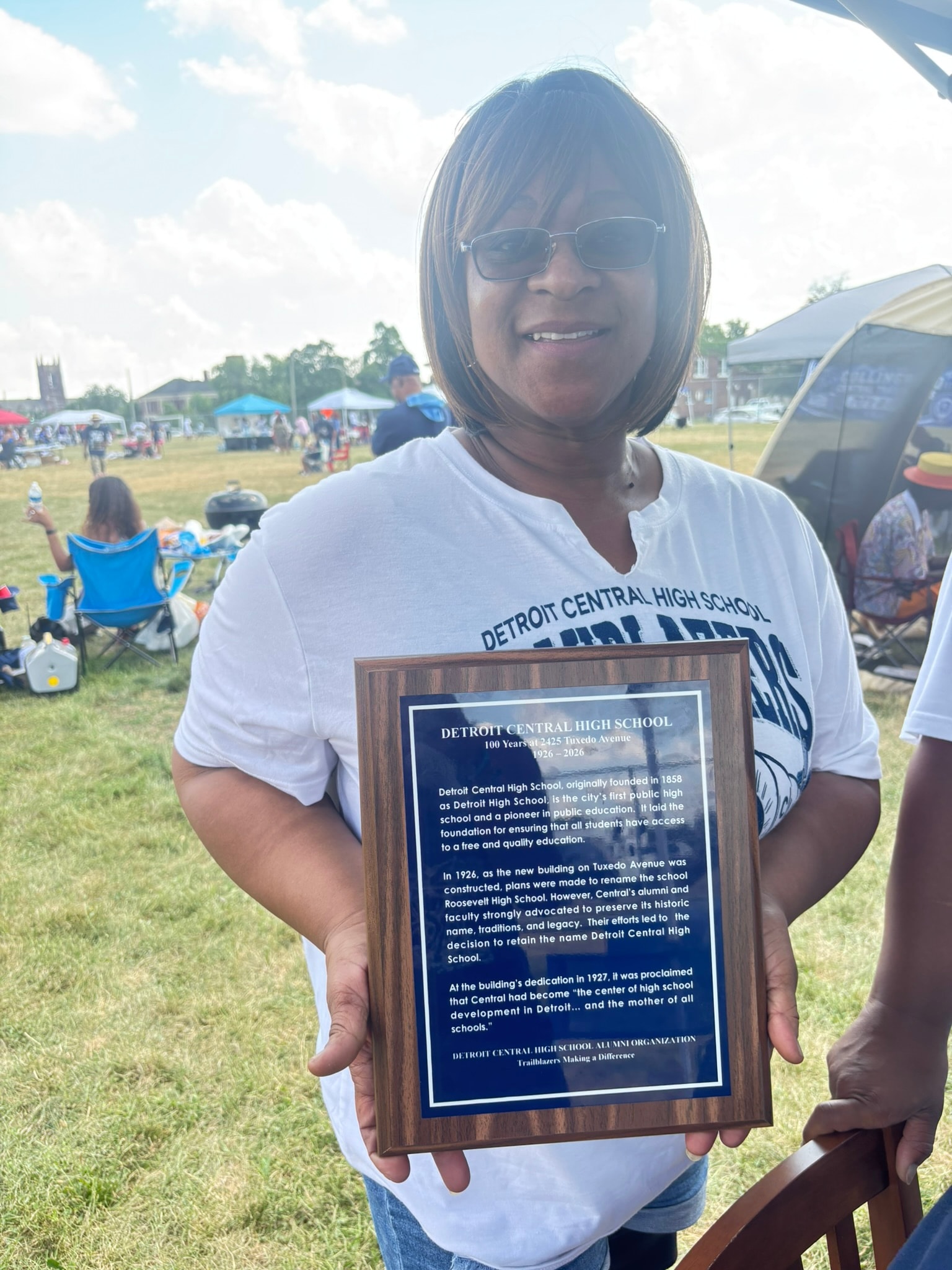 Woman holding Detroit Central High School plaque