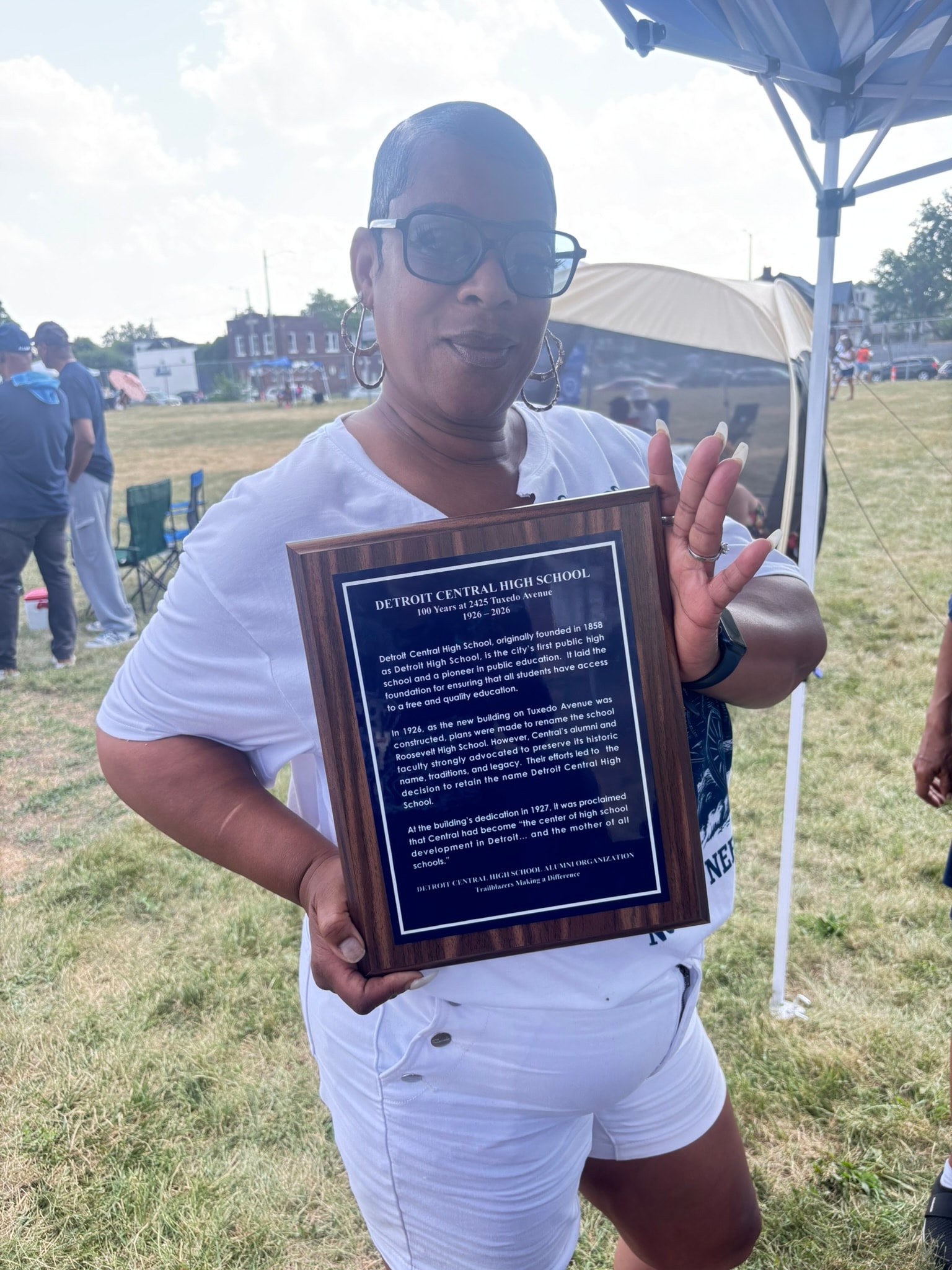 Woman holding Detroit Central High School plaque