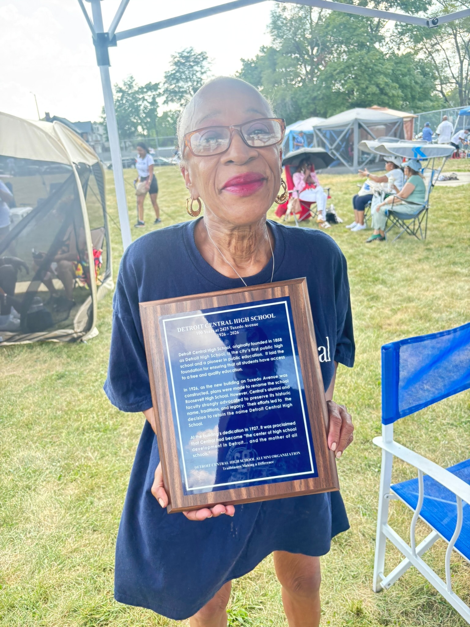 Woman holding Detroit Central High School plaque