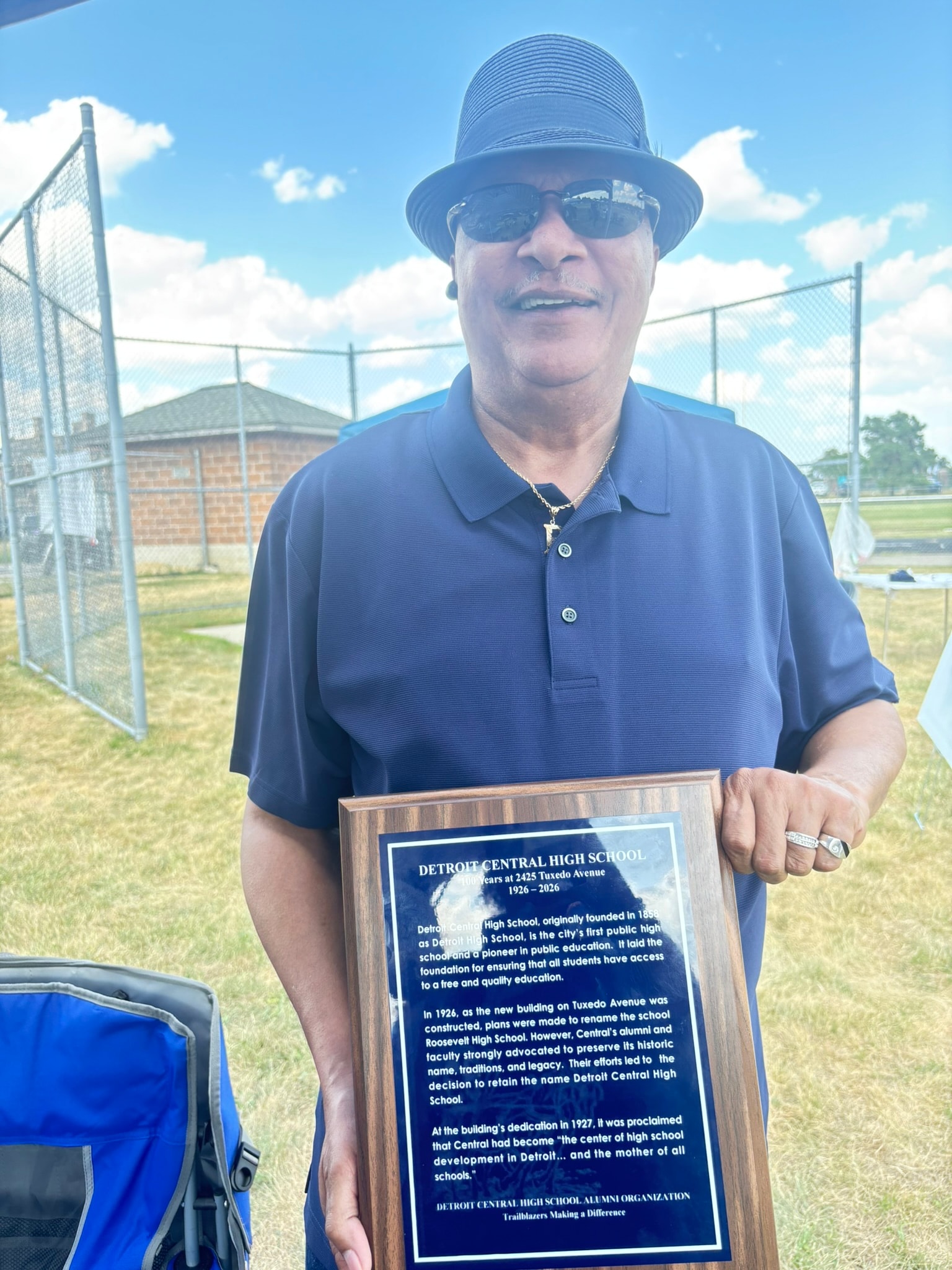 Man holding Detroit Central High School plaque