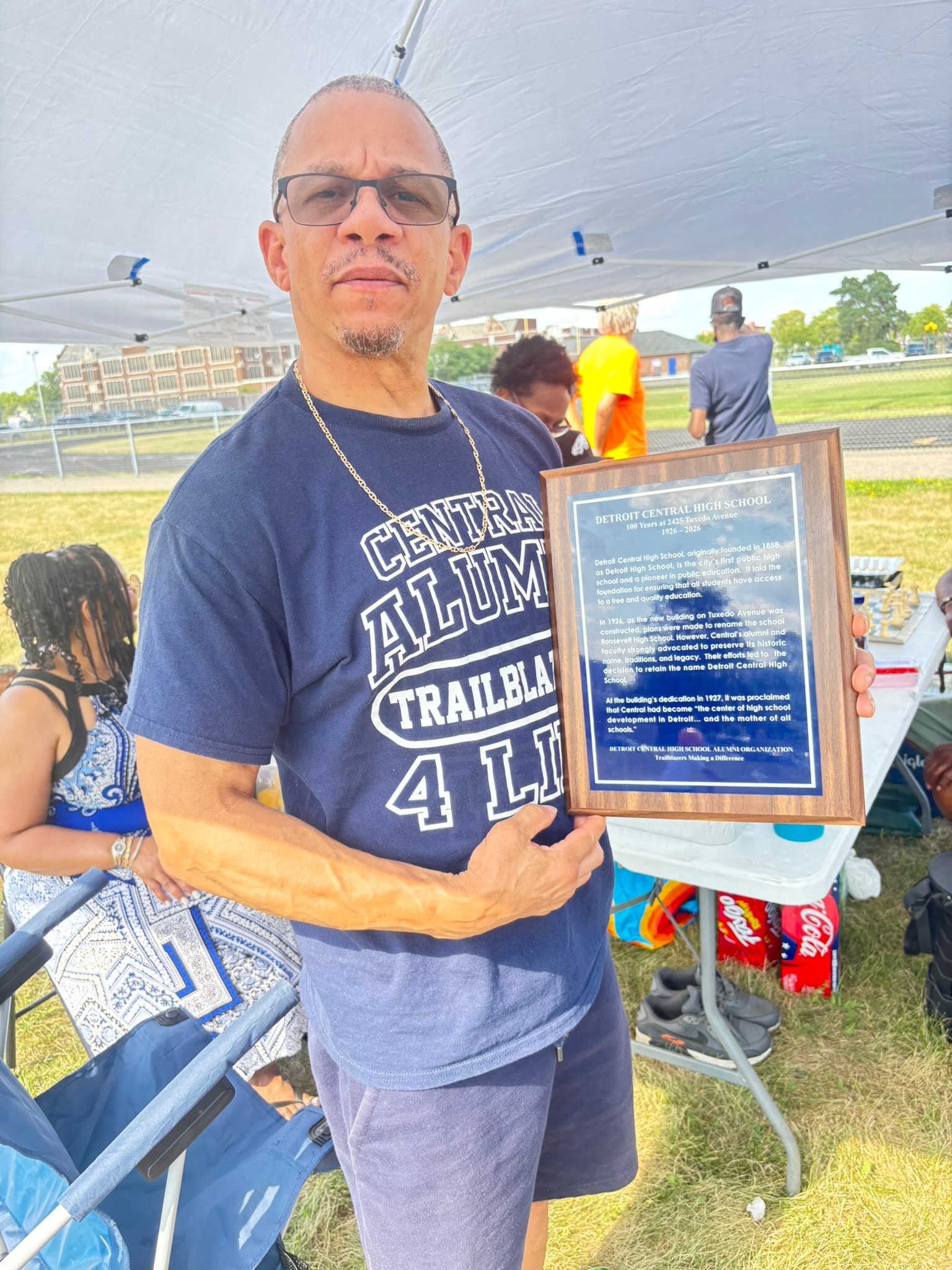 Man holding Detroit Central High School plaque