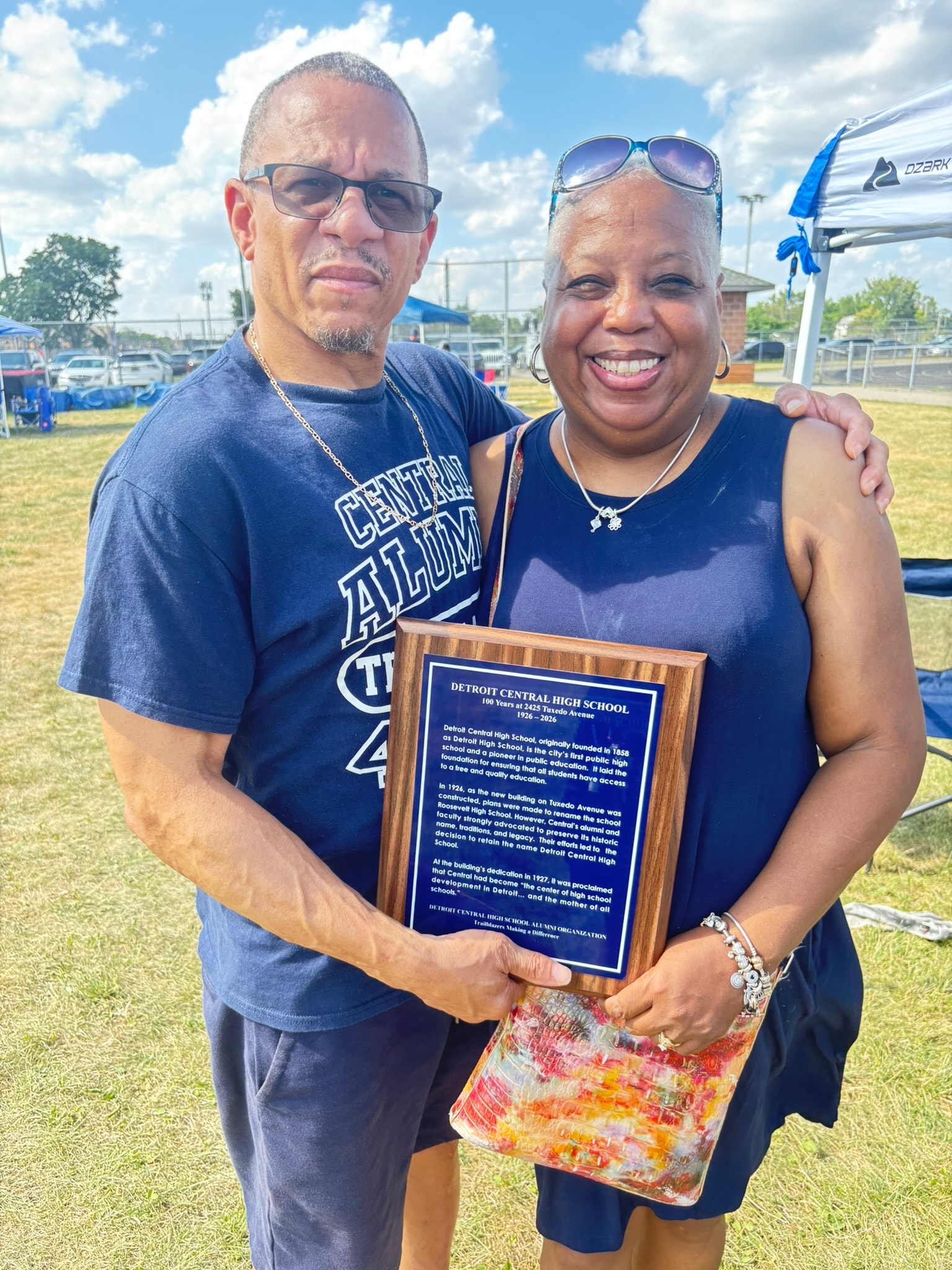 Two alumni holding Detroit Central High School plaque