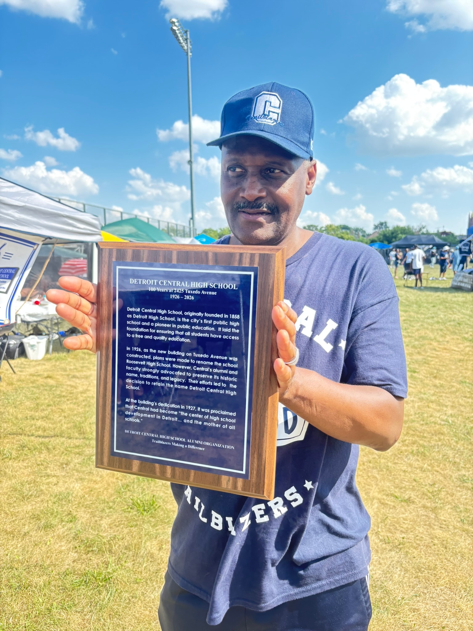 Man holding Detroit Central High School plaque