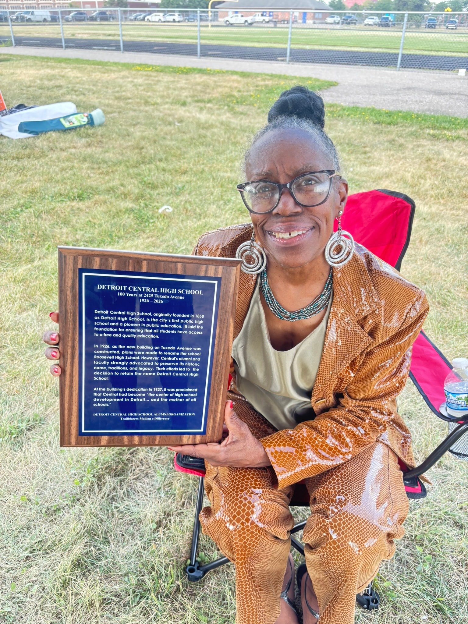 Woman holding Detroit Central High School plaque