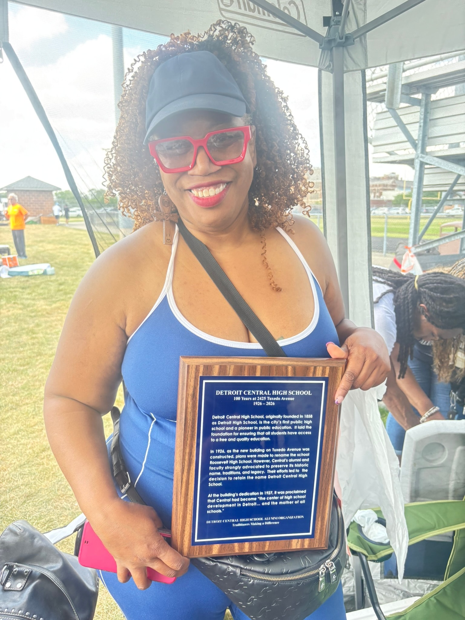 Woman holding Detroit Central High School plaque