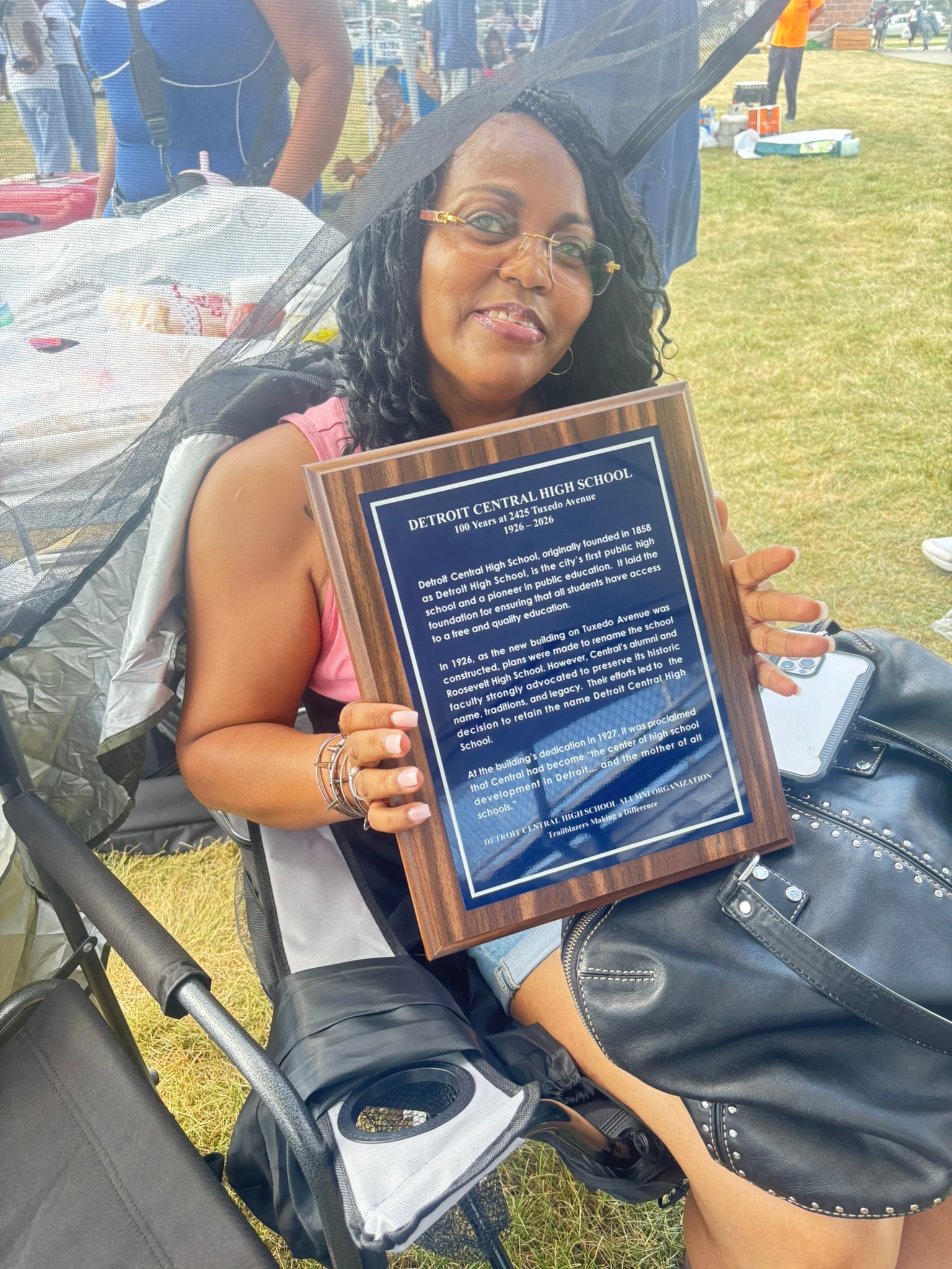 Woman holding Detroit Central High School plaque