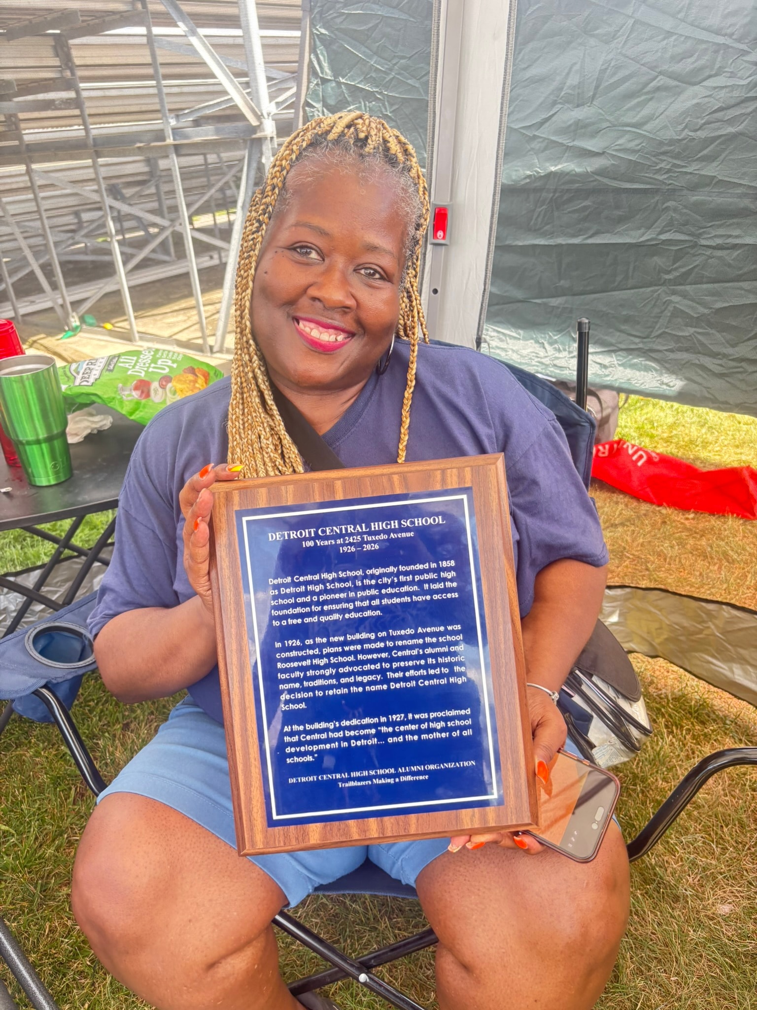 Woman holding Detroit Central High School plaque