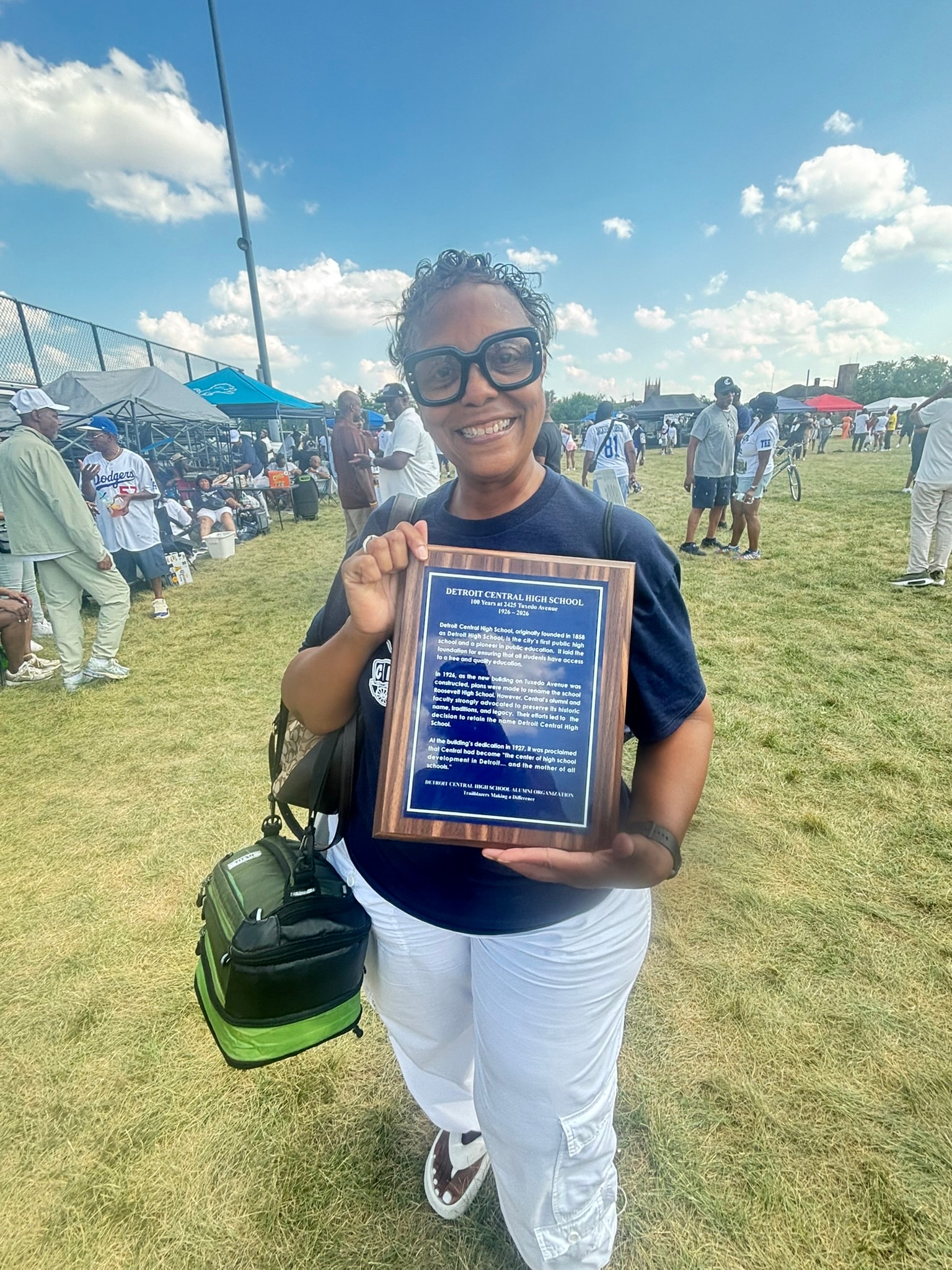 Woman holding commemorative plaque outdoor event