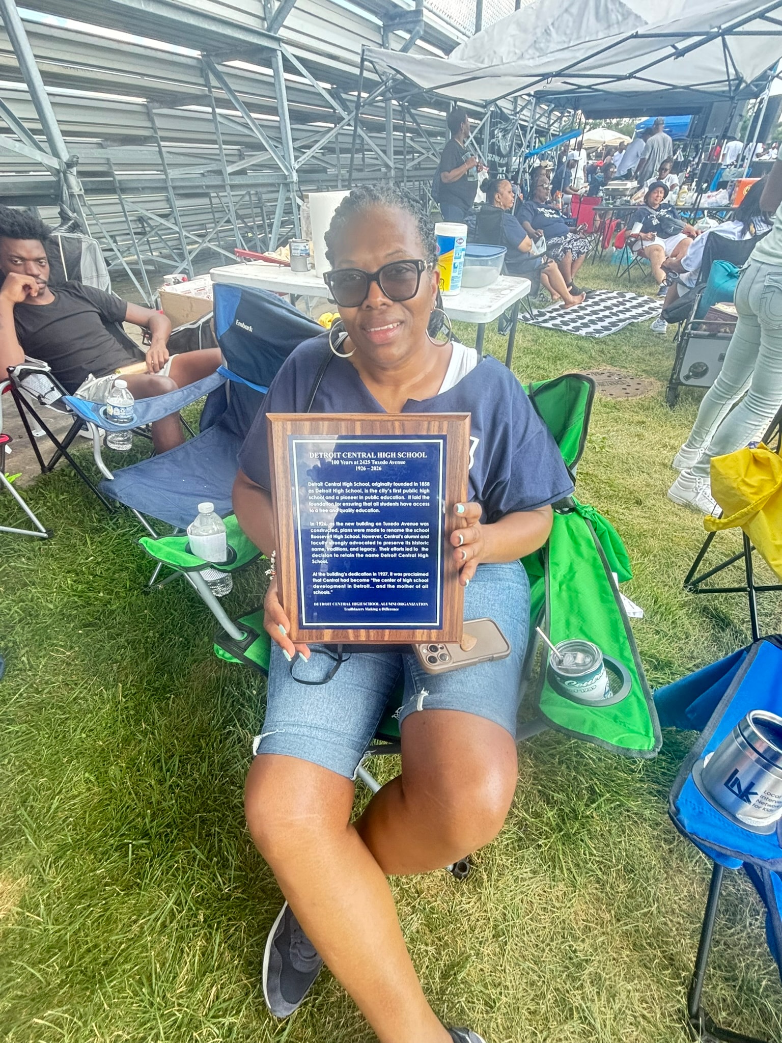 Woman holding commemorative plaque outdoor event