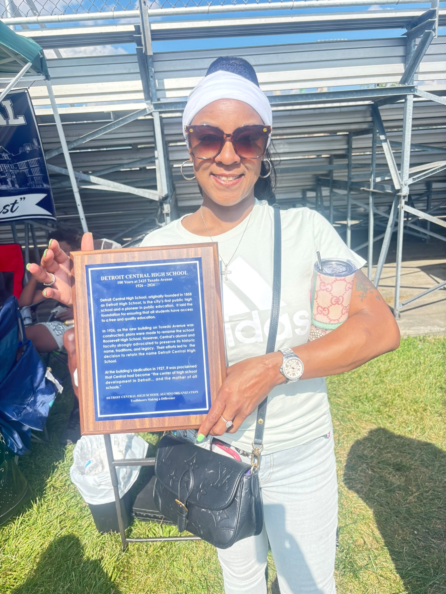 Woman holding Detroit Central High School plaque