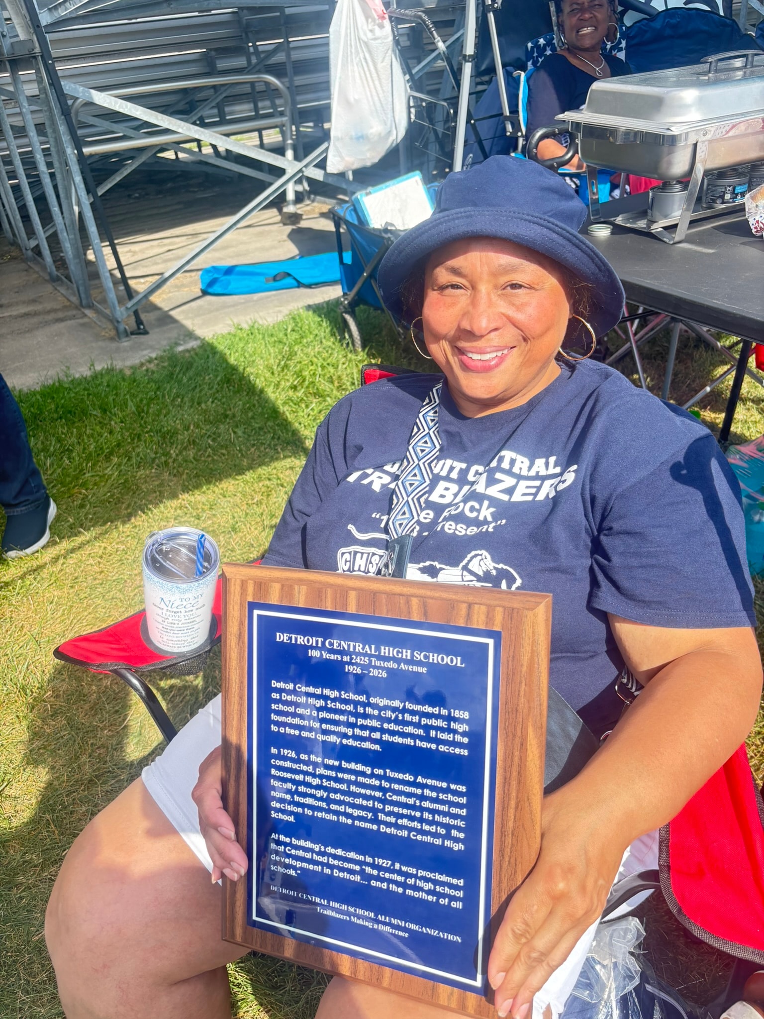 Woman holding Detroit Central High School plaque