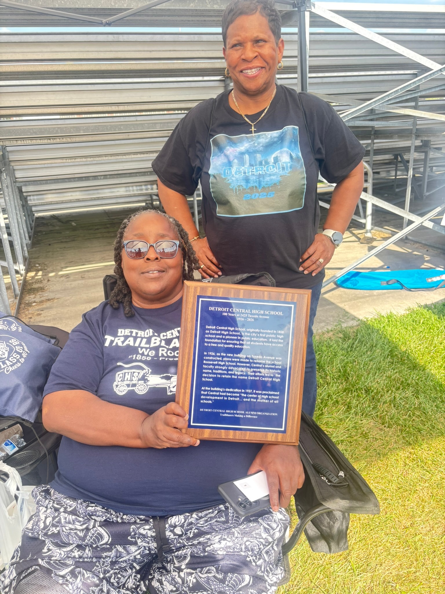 Woman and girl holding Detroit Central High School plaque
