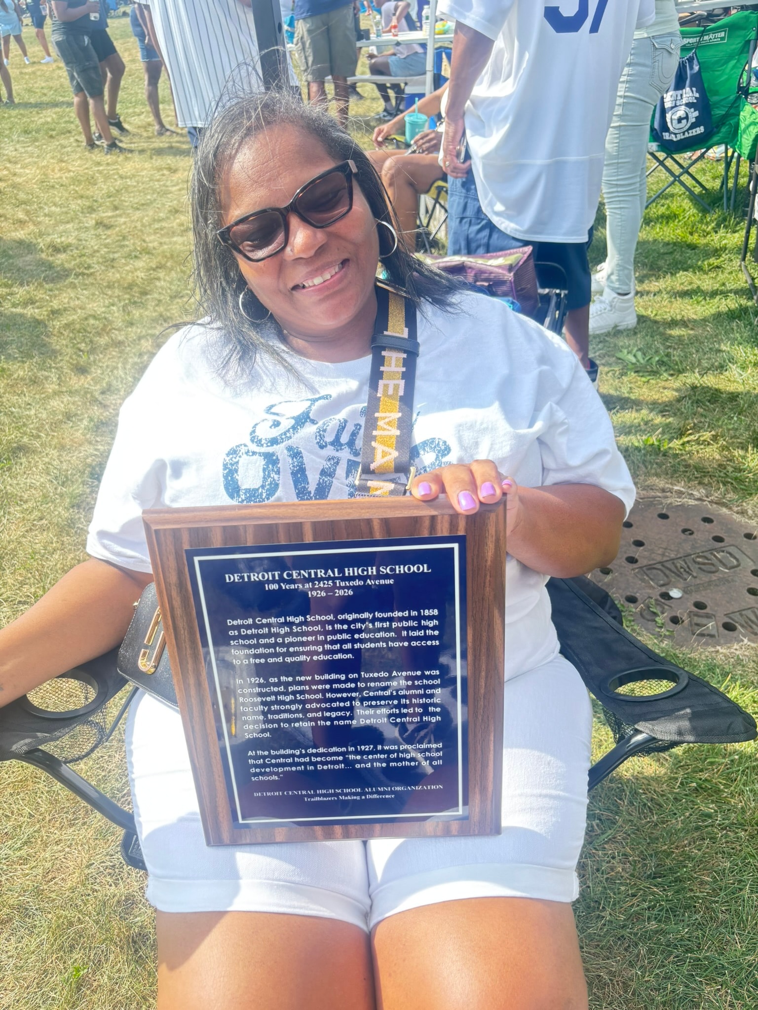 Woman holding Detroit Central High School plaque
