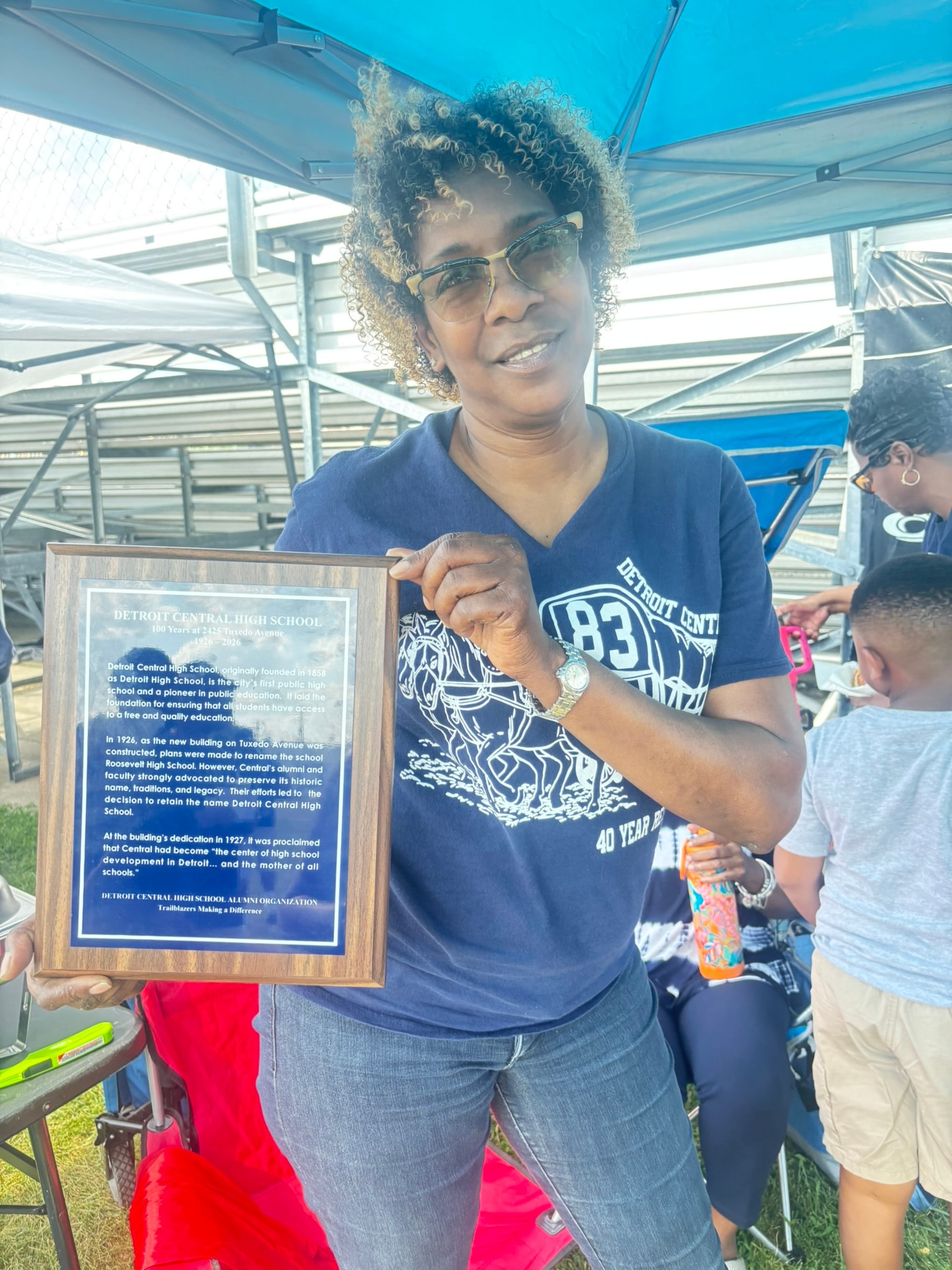 Woman holding Detroit Central High School plaque